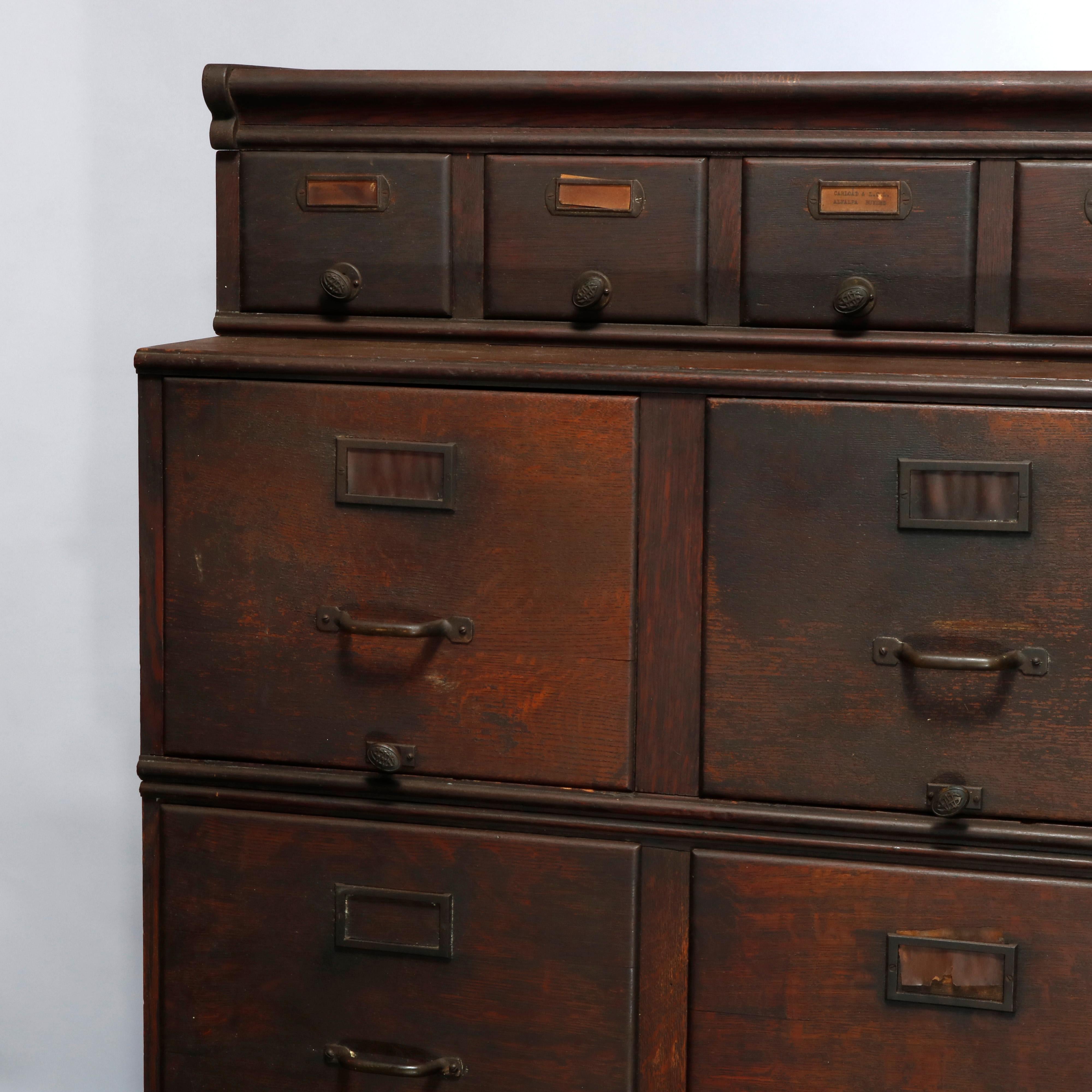 An antique Arts & Crafts fining cabinet offers oak construction with three stacks having upper with card catalog drawers and lower with standard filing drawers, cast pulls with embossed SW, c1910

Measures: 36.5