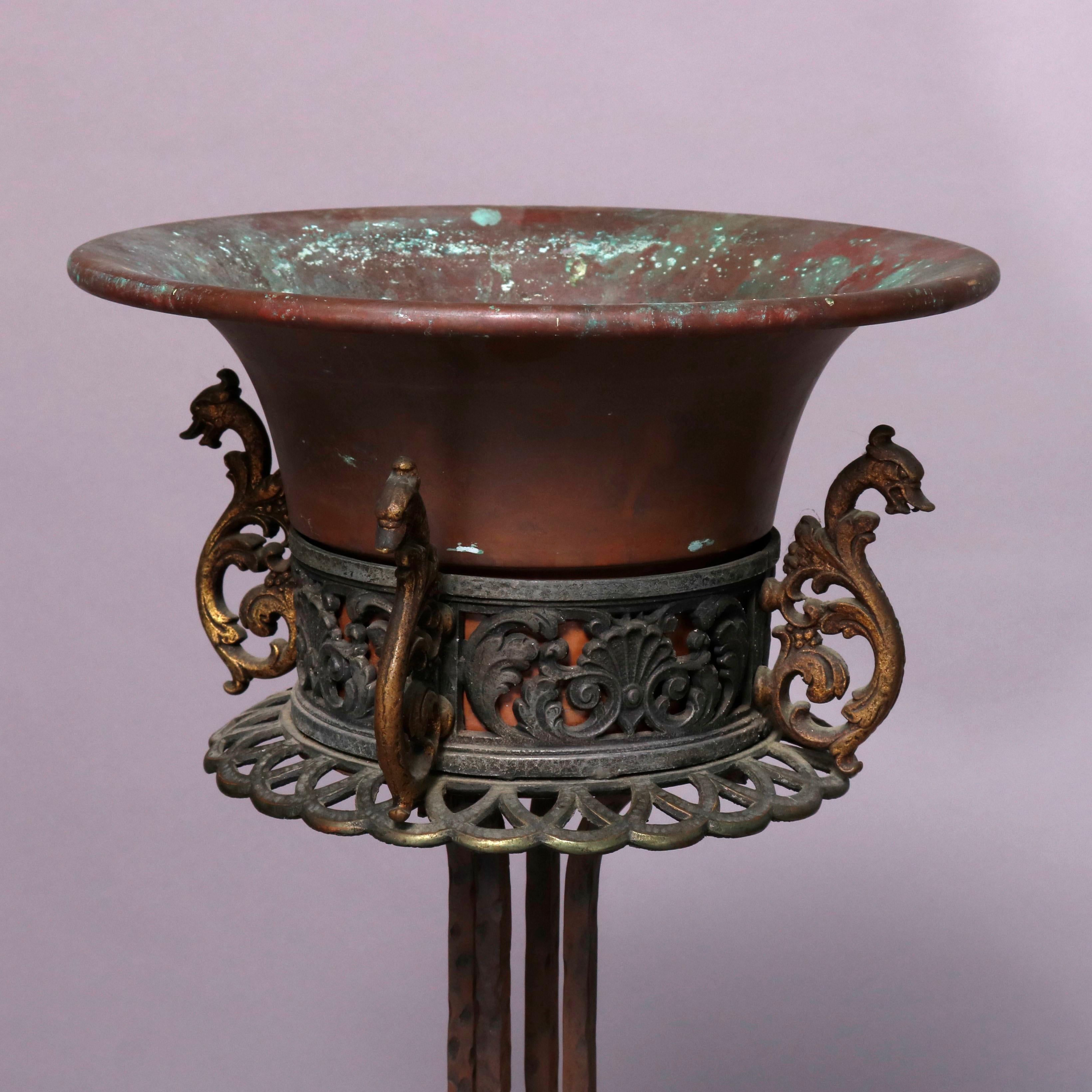 An antique Arts & Crafts figural planter by Oscar Bach offers bronze construction with pierced tray having foliate elements and sea horses with flared insert and surmounting cluster twisted column pedestal on faceted base with sea horses, circa