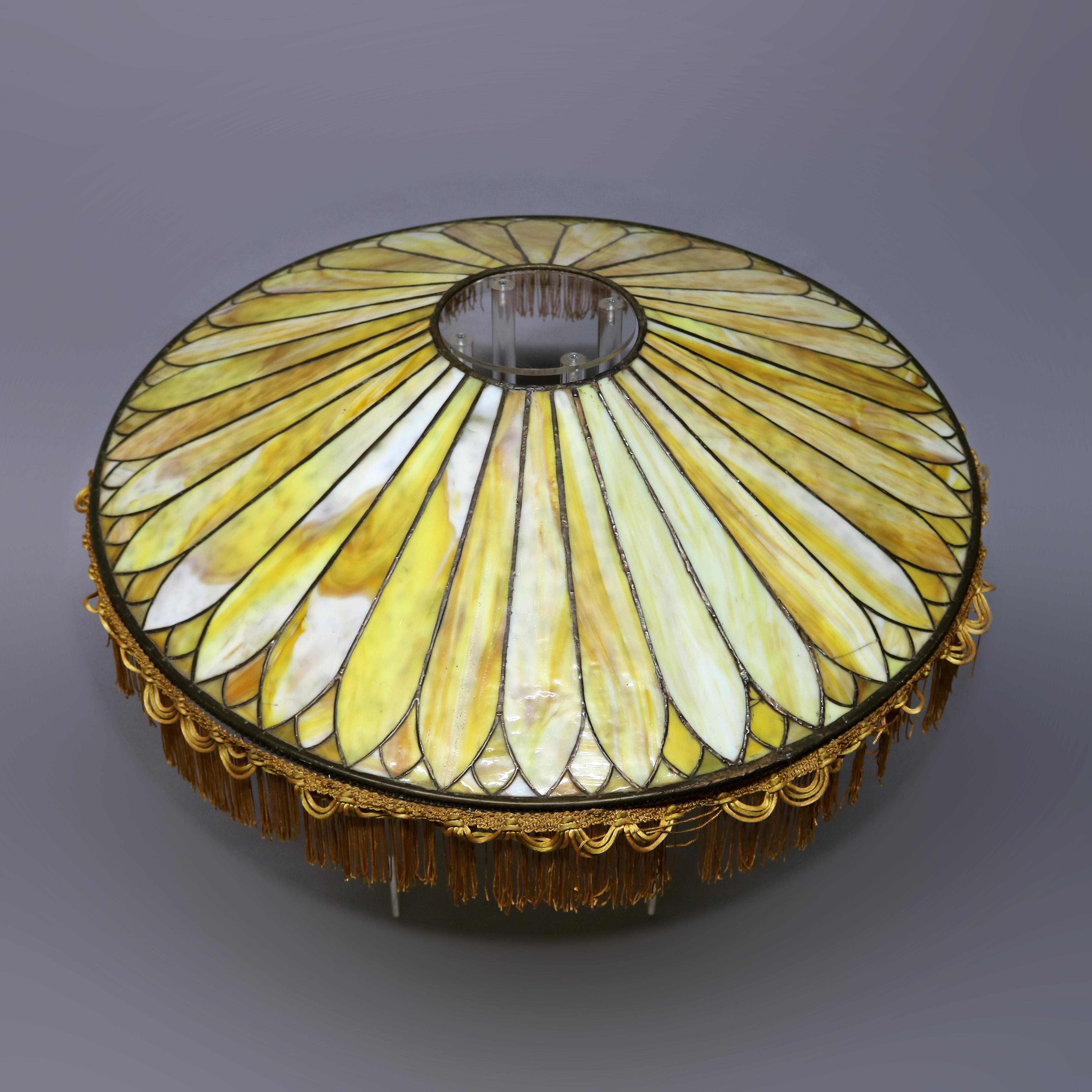 An antique oversized Arts & Crafts Prairie School lamp shade offers leaded slag glass construction in dome form with stylized petal design and fringed edge, circa 1910.

Measures: 6.5