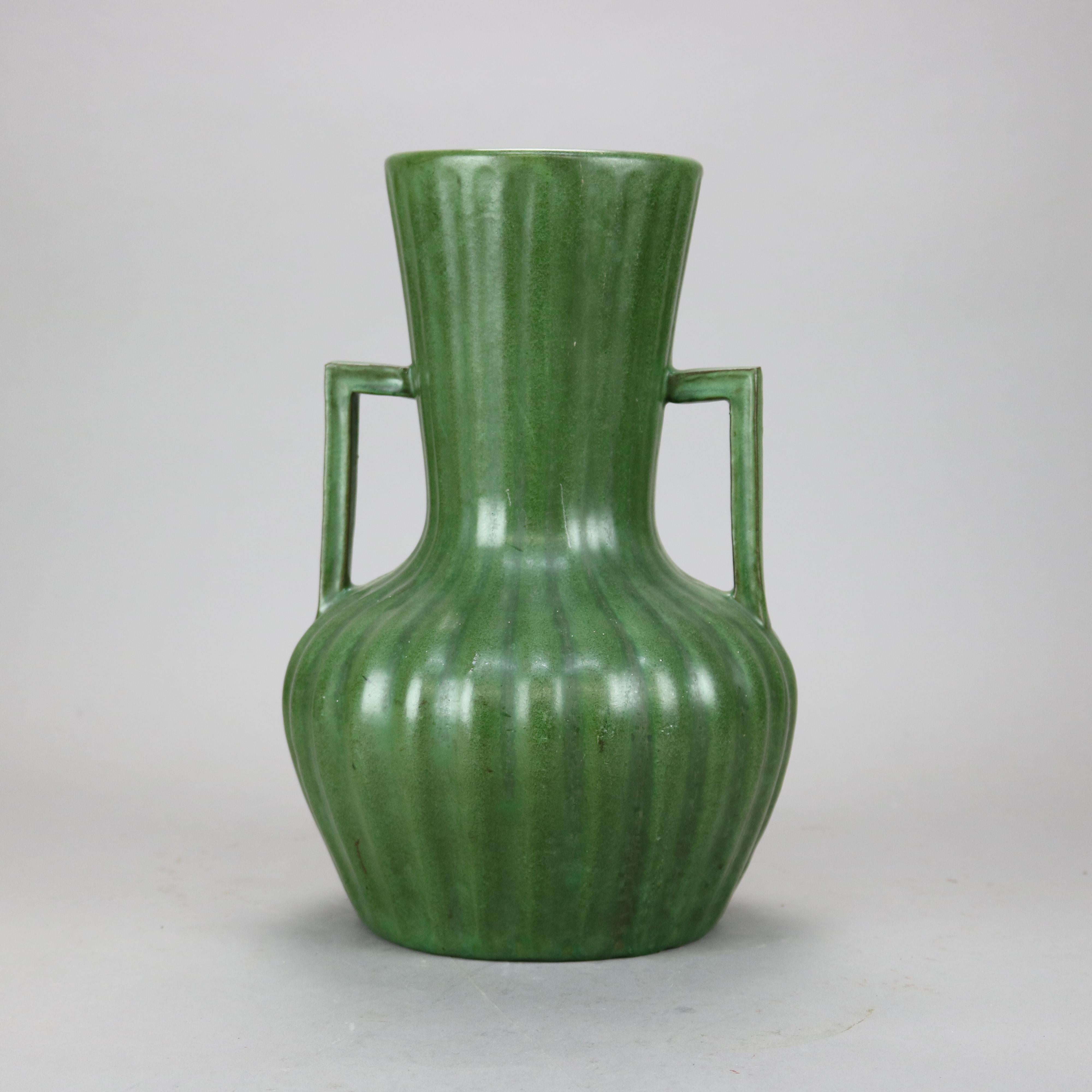 An antique Arts & Crafts vase by Peters and Reed offers art pottery construction in reeded bulbous form with double flanking handles, unmarked, c1910

Measures - 13.5'' H x 8.75' W x 8.75'' D.