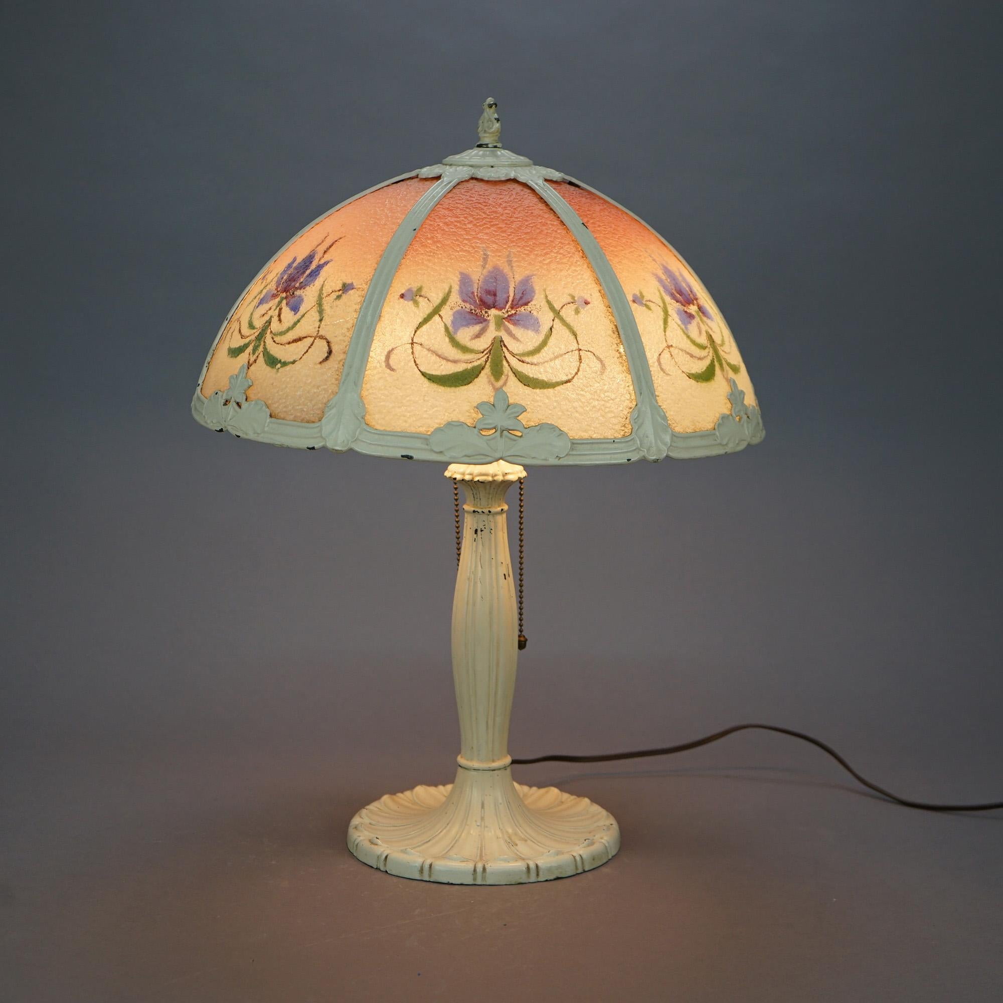 An antique Arts and Crafts Pittsburg table lamp offers dome form shade with cast frame housing bent glass panels having reverse painted flowers over double socket base, c1920

Measures- 21.25''H x 16''W x 16''D.