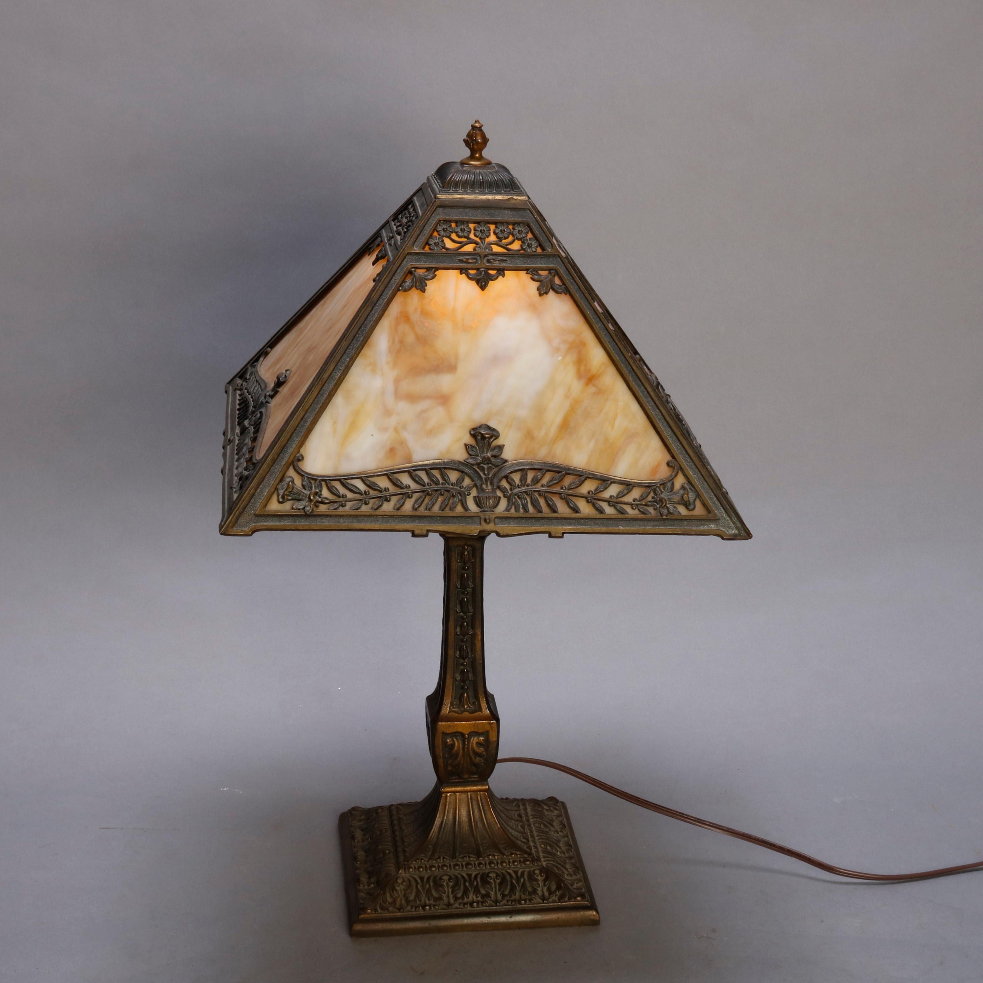 An antique Arts & Crafts table lamp by Pittsburgh Lamp Co. offers foliate cast filigree shade housing slag glass panels surmounting cast single socket base, signed PL&B, circa 1920.

Measures: 20.5