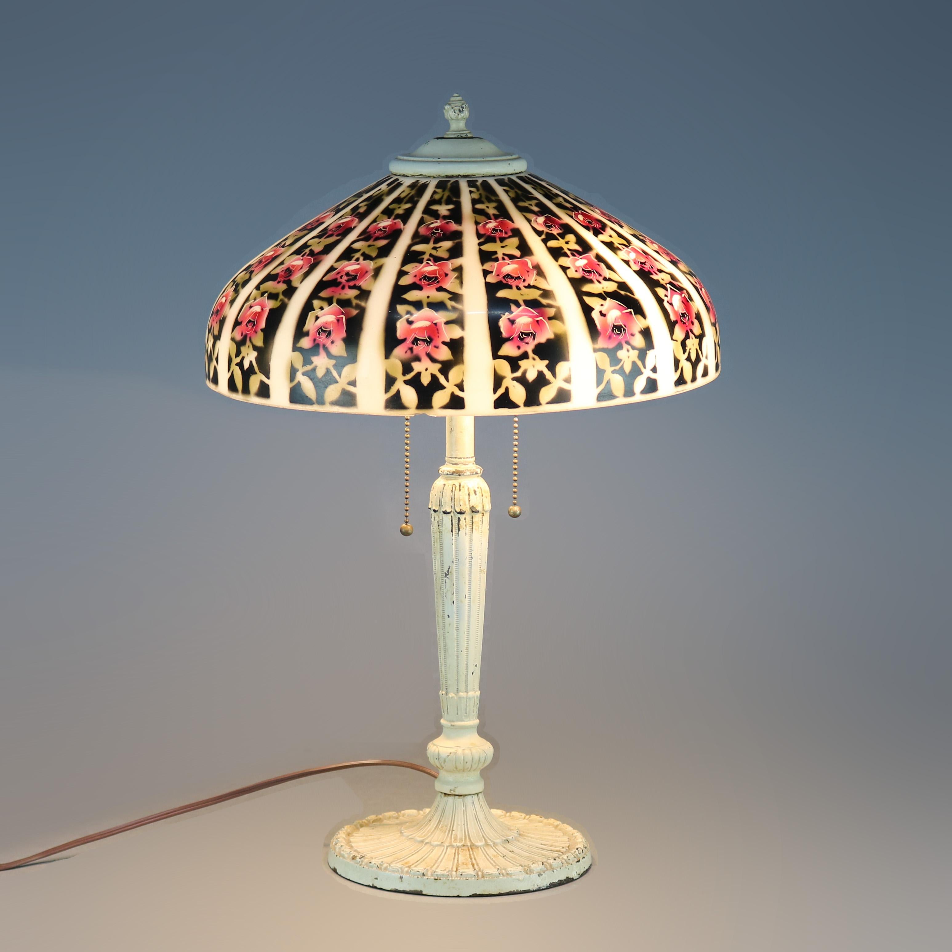 An antique Arts & Crafts table lamp by Pittsburgh Lamp Co. offers obverse painted shade with repeating pattern of floral stripes over cast base having dual independently controlled sockets, circa 1920.

Measures: 21