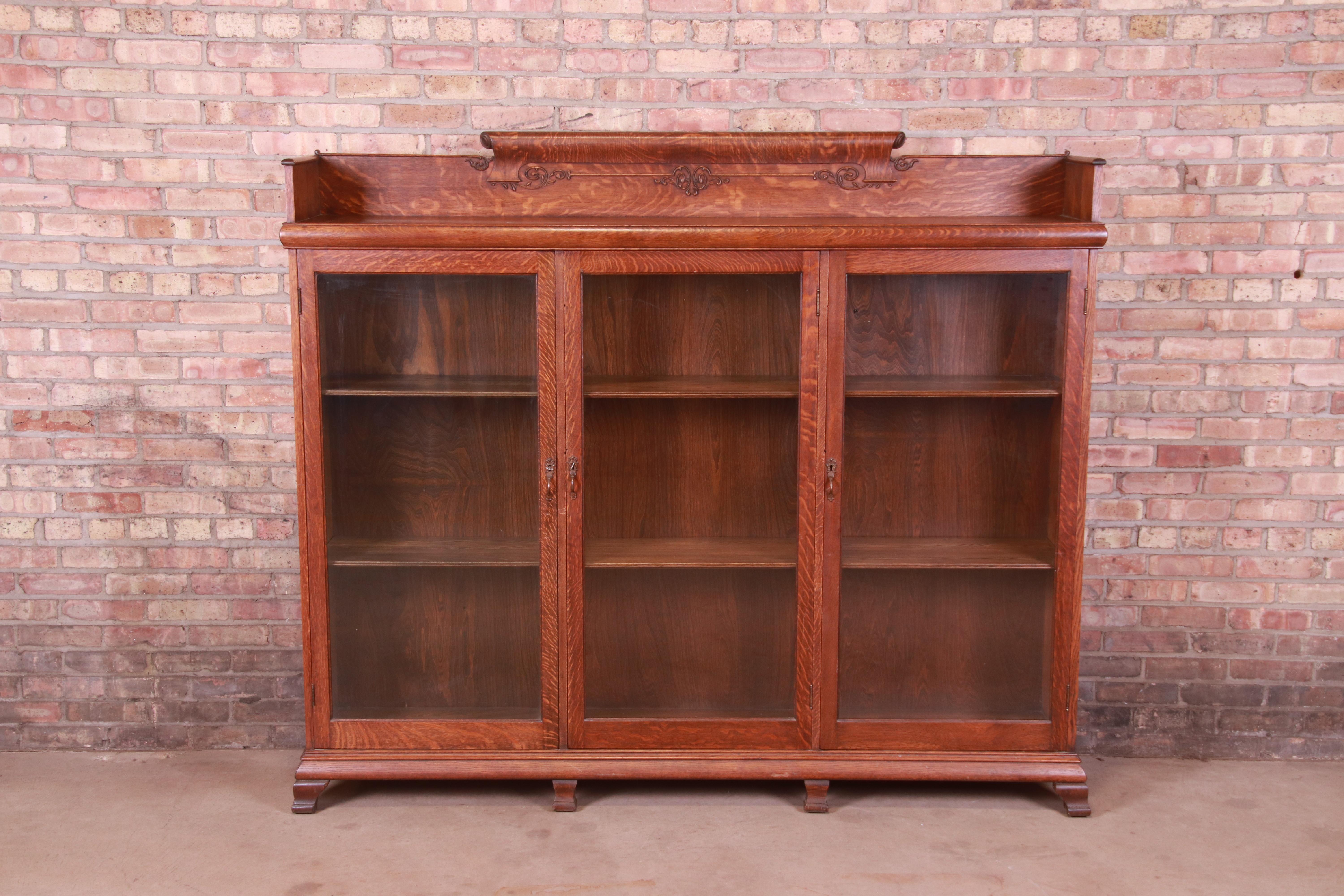 A gorgeous antique Arts & Crafts triple bookcase cabinet

USA, Circa 1900

Carved quarter sawn oak, with glass front doors and brass hardware.

Measures: 73