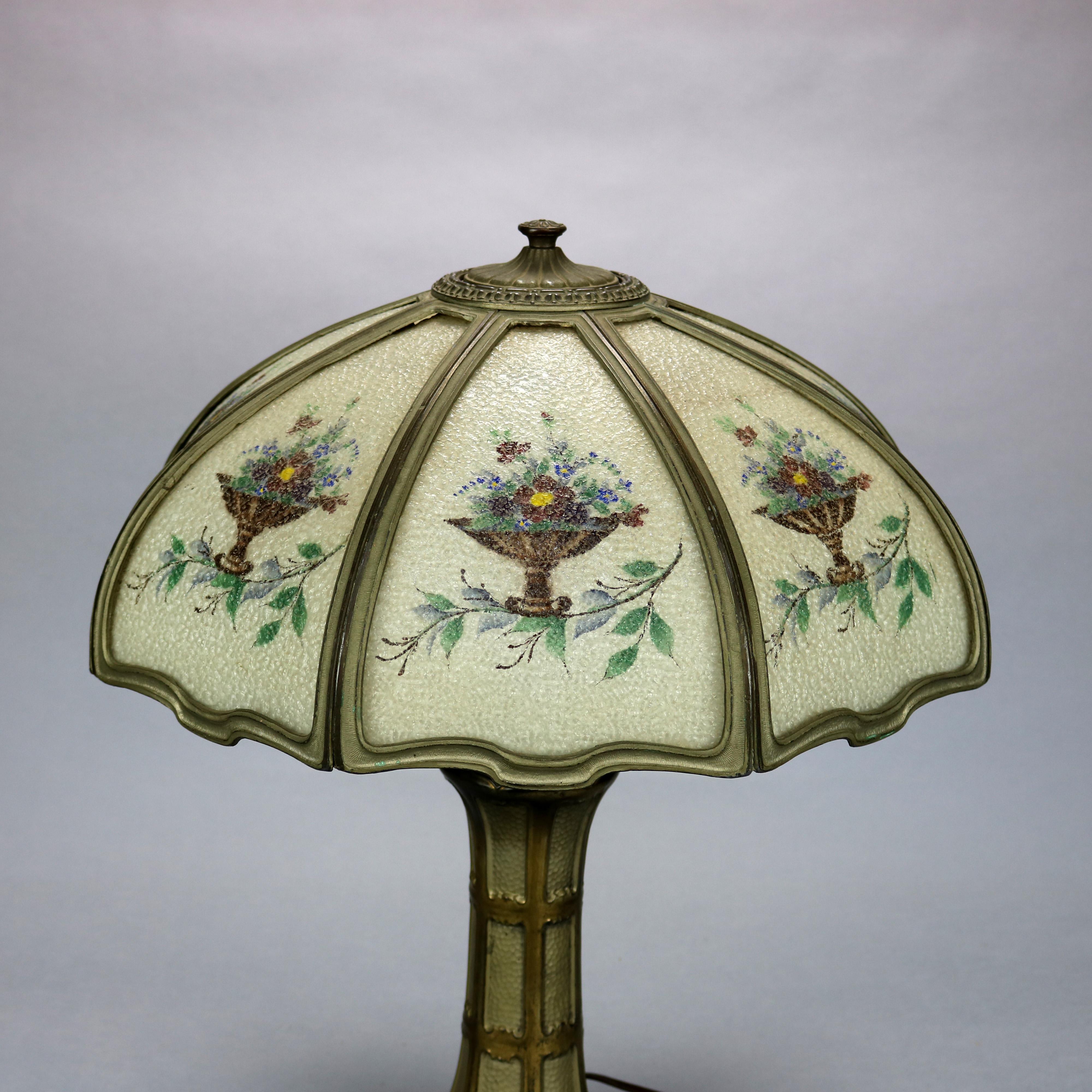 An Arts & Crafts table lamp offers hand painted floral panels seated in cast frame over double socket base, c1920

Measures: 23