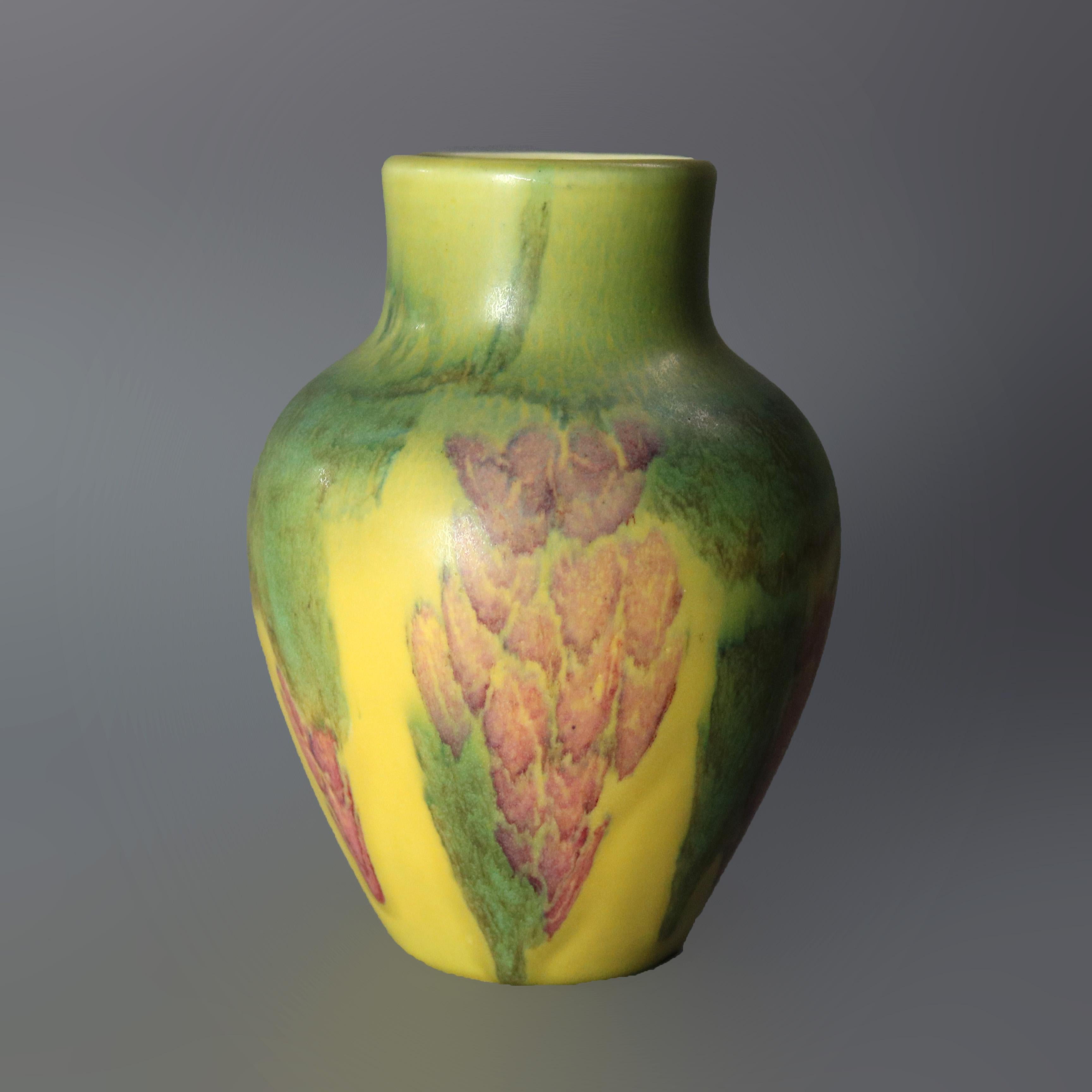An antique Arts and Crafts vase by Rookwood offers art pottery construction with hand painted abstract floral or grape and leaf design, marked on base as photographed, 1928

Measures: 7.5