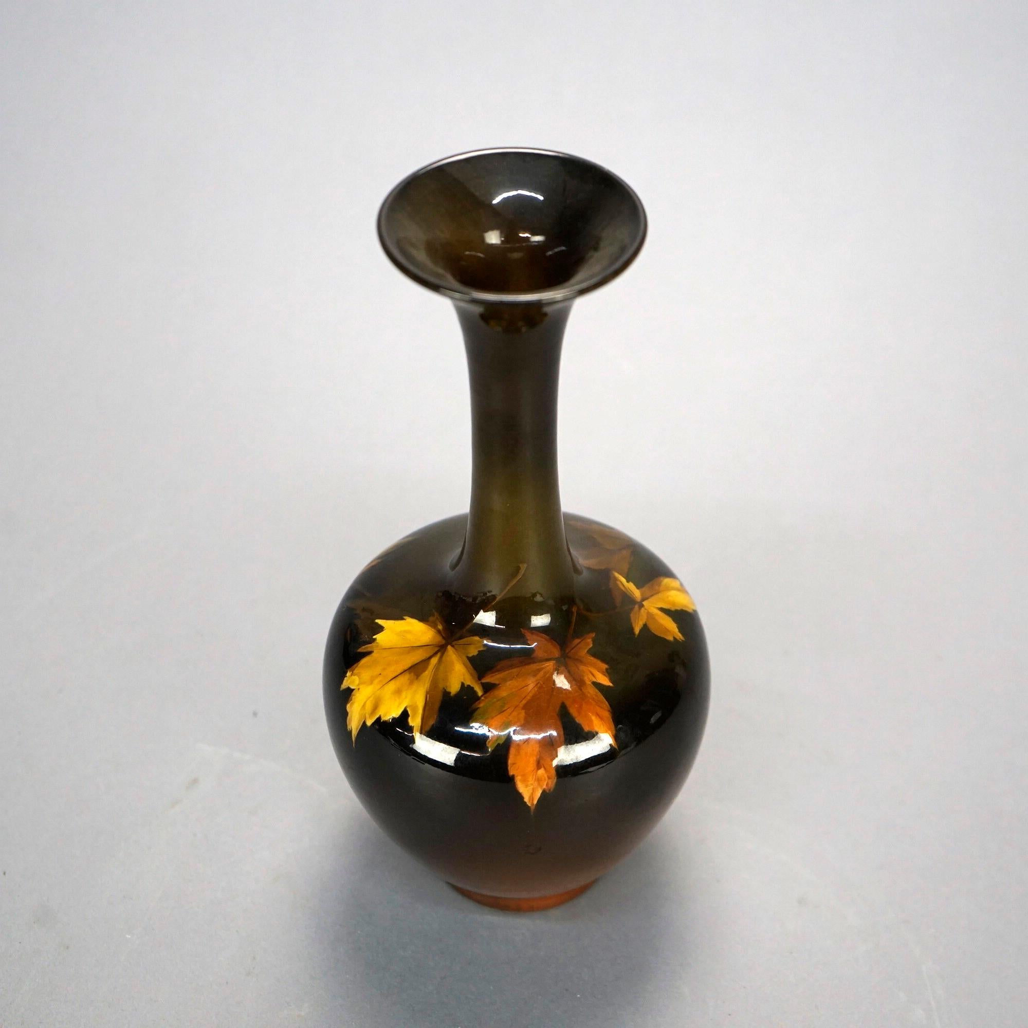 An antique Arts and Crafts vase by Rookwood offers art pottery construction in bulbous form with extended neck termination in flared mouth, hand painted collar of fall maple leaves, maker mark on base as photographed, c1930

Measures- 9''H x 4.25''W