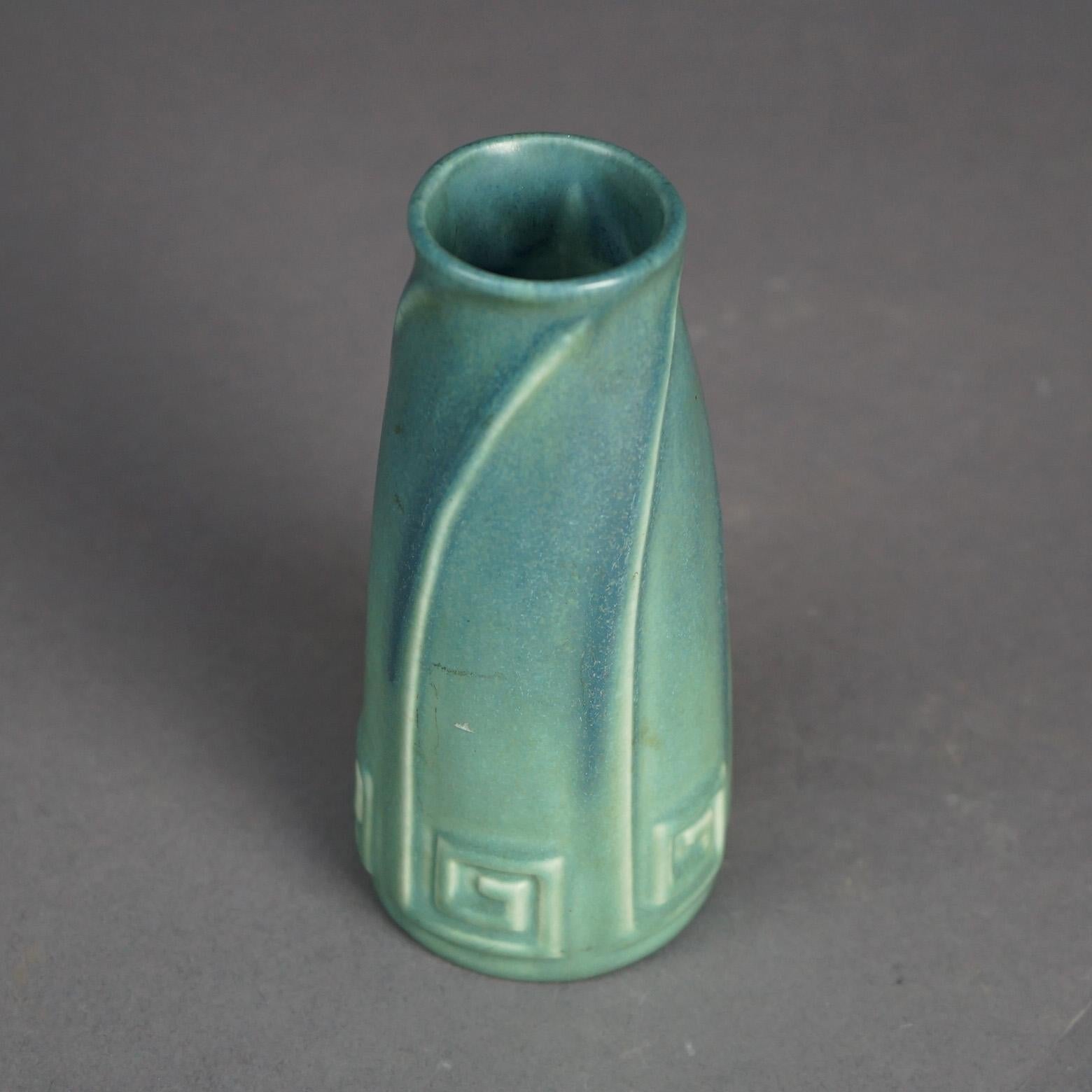 An antique Arts and Crafts vase by Rookwood offers matt glazed art pottery construction with stylized Greek Key and swirl elements, signed on base as photographed, c1923

Measures- 6''H x 2.75''W x 2.75''D