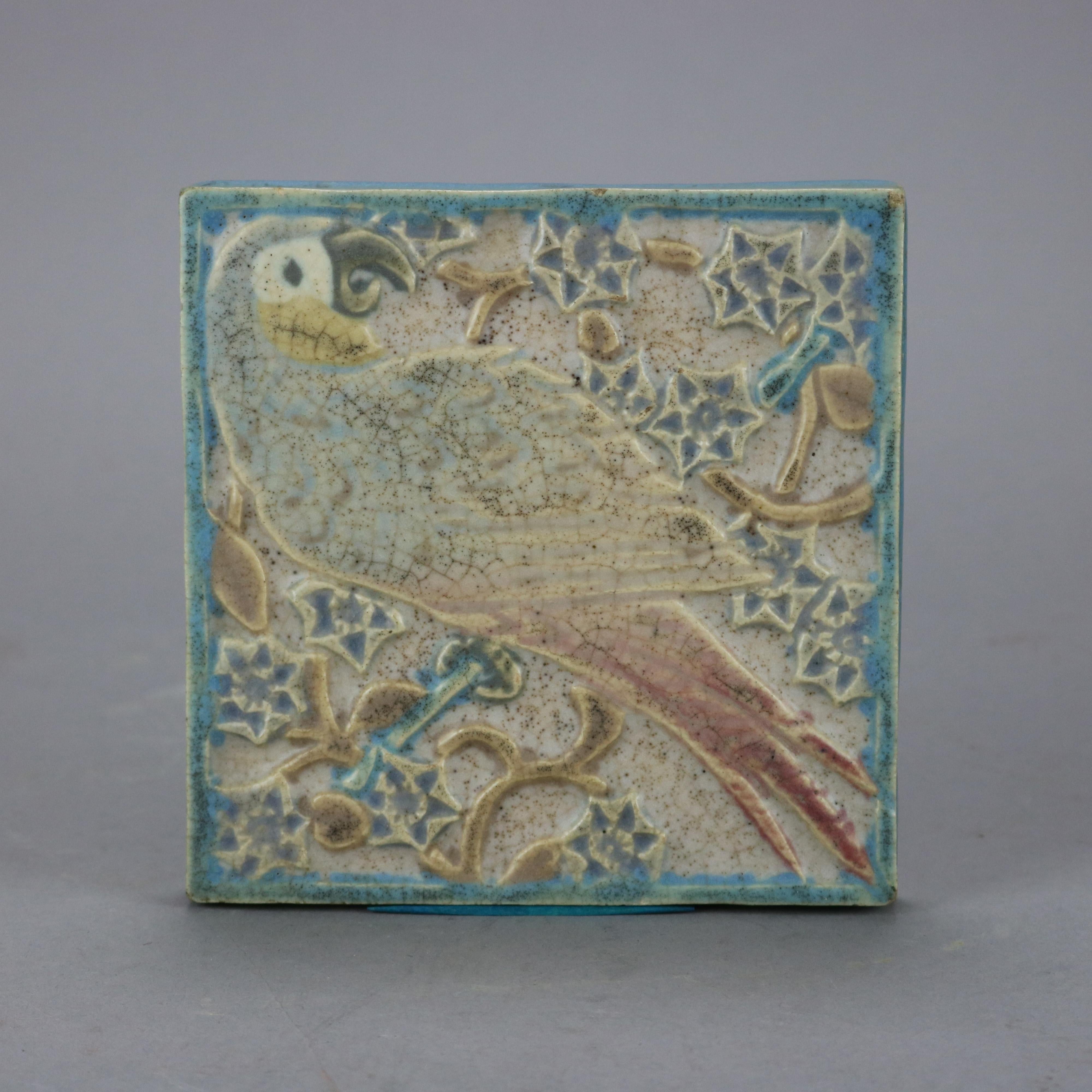 An antique Arts & Crafts tile trivet by Rookwood offers a parrot and foliate elements in relief, en verso marked as photographed, dated 1917

Measures - .5''H x 5.75''W x 5.75''D.