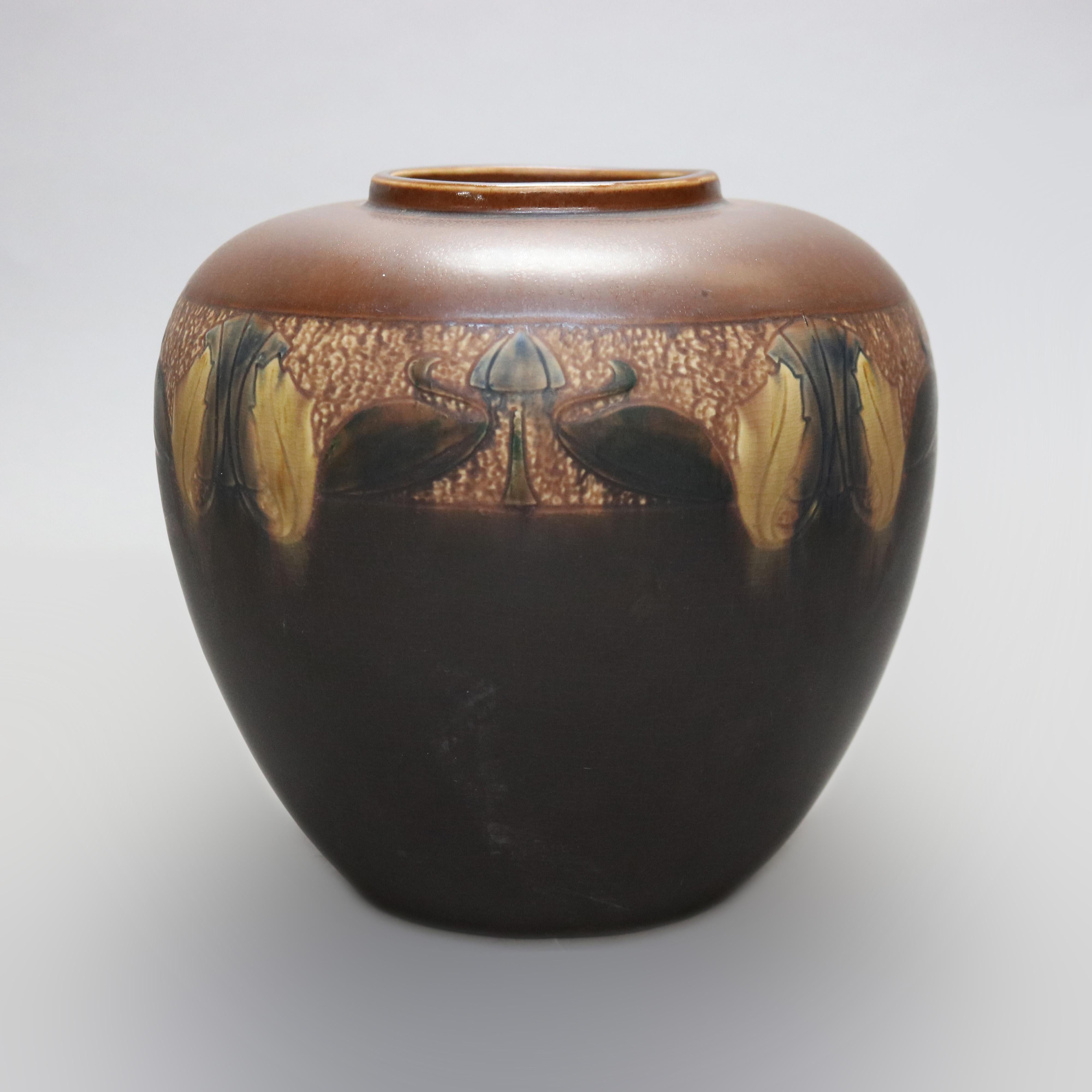 An antique Arts and Crafts vase attributed to Roseville Pottery offers art pottery construction having two tone glaze with stylized leaf and swan band, unsigned, c1910

Measures - 9.5''H x 9.5''W x 9.5''D.