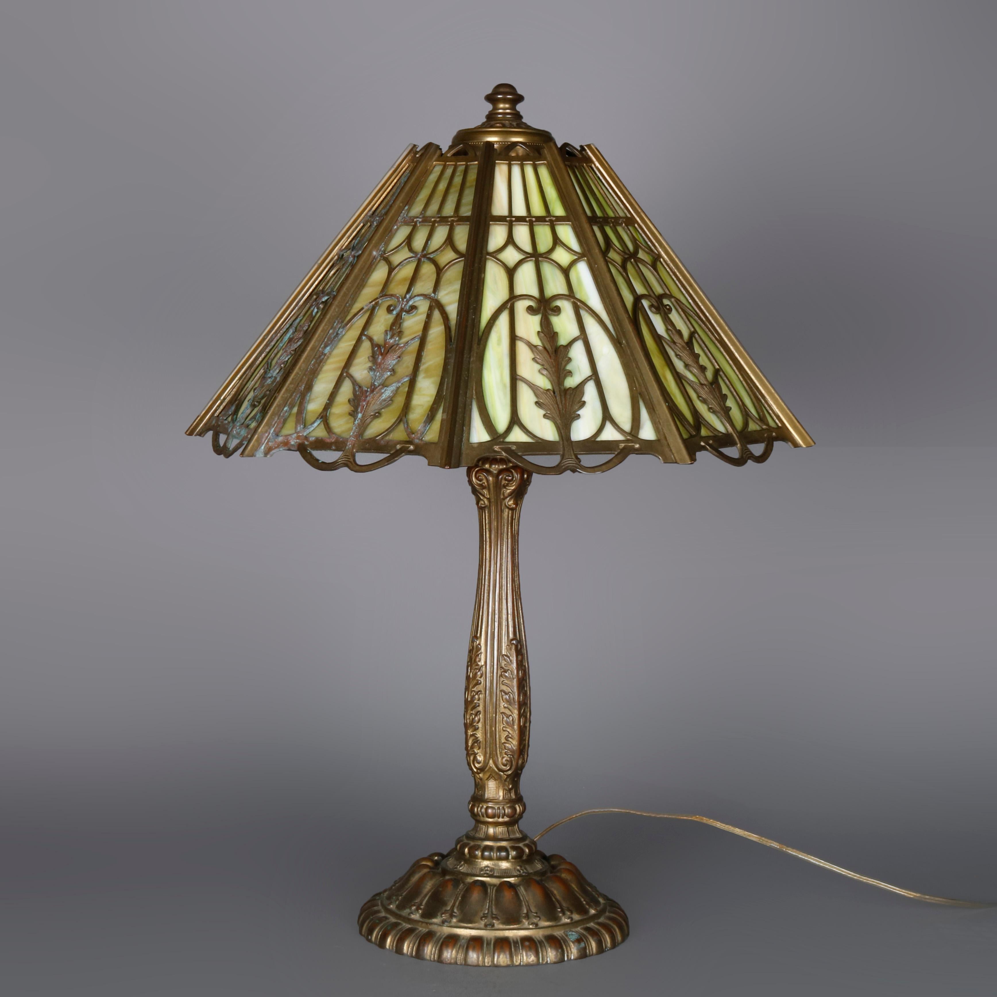 An antique Arts & Crafts table lamp by Wilkinson offers shade with cast bronze overlay with nine slag glass panels surmounting cast bronze base with three sockets and signed on base as photographed, circa 1910

***DELIVERY NOTICE – Due to COVID-19