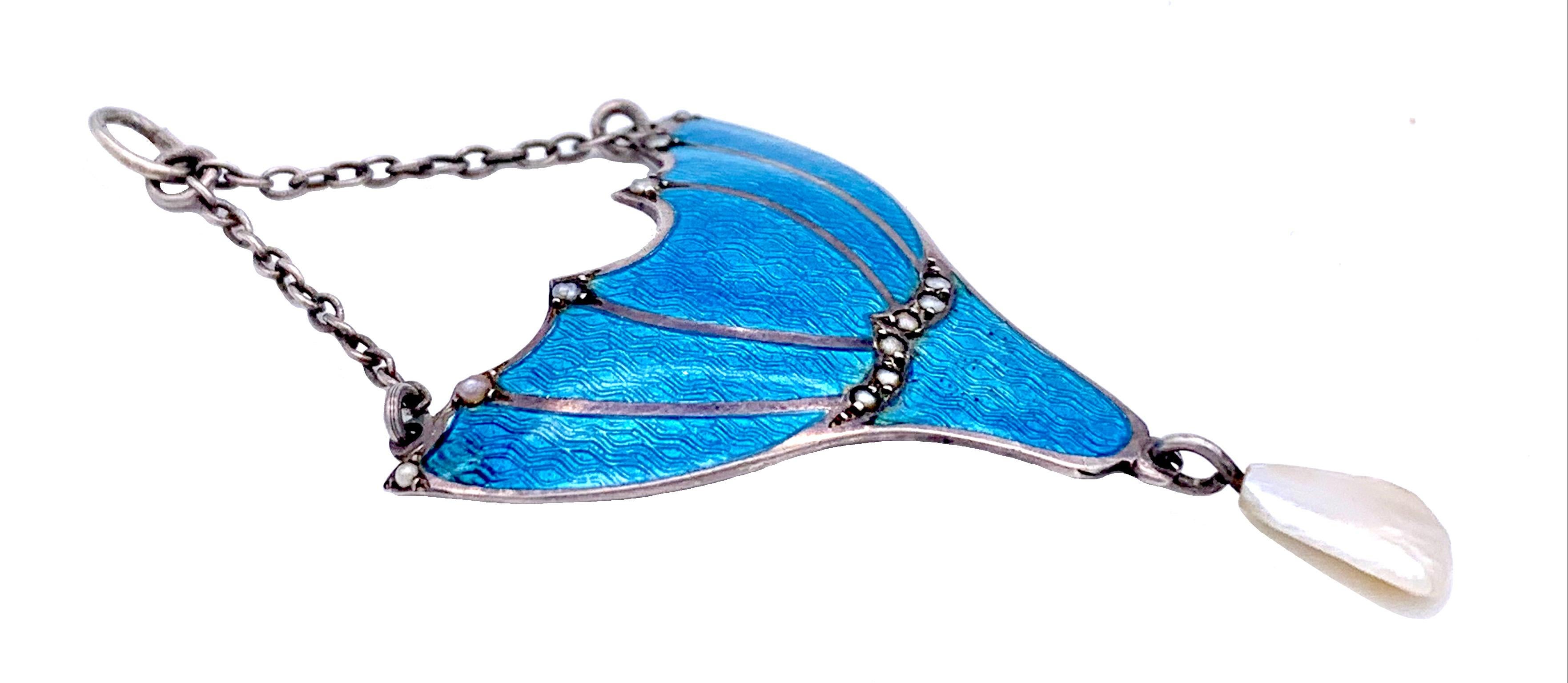 Ce pendentif Arts & Crafts est fabriqué à la main en argent sterling et recouvert d'un fin émail guilloché bleu intense présentant un motif de vagues. Ce charmant motif, qui rappelle une fleur, est agrémenté de petites perles naturelles orientales