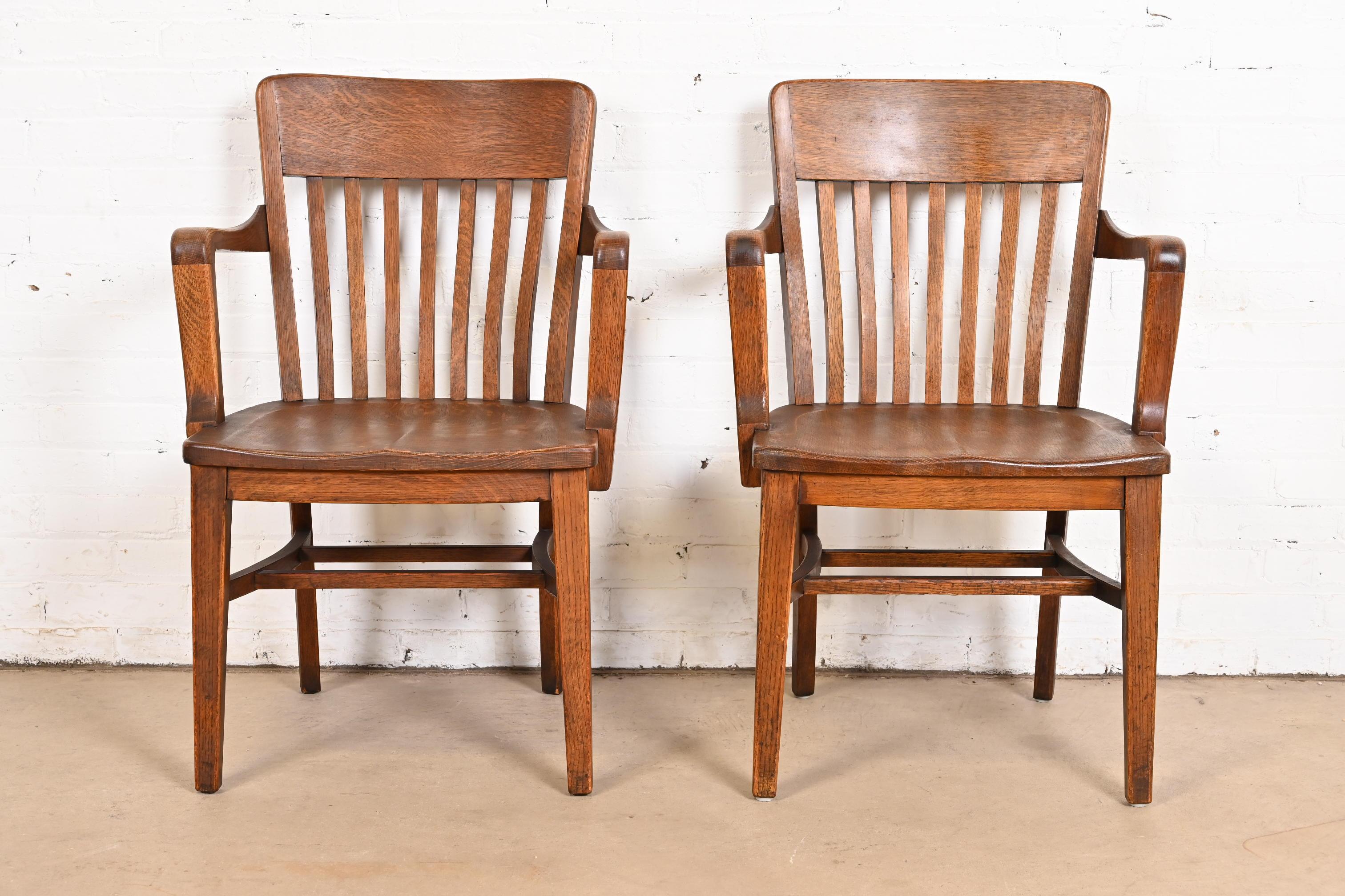 A gorgeous pair of antique solid quarter sawn oak banker, juror, or lawyer chairs

In the manner of Heywood Wakefield

USA, Early 20th Century

Measures: 23