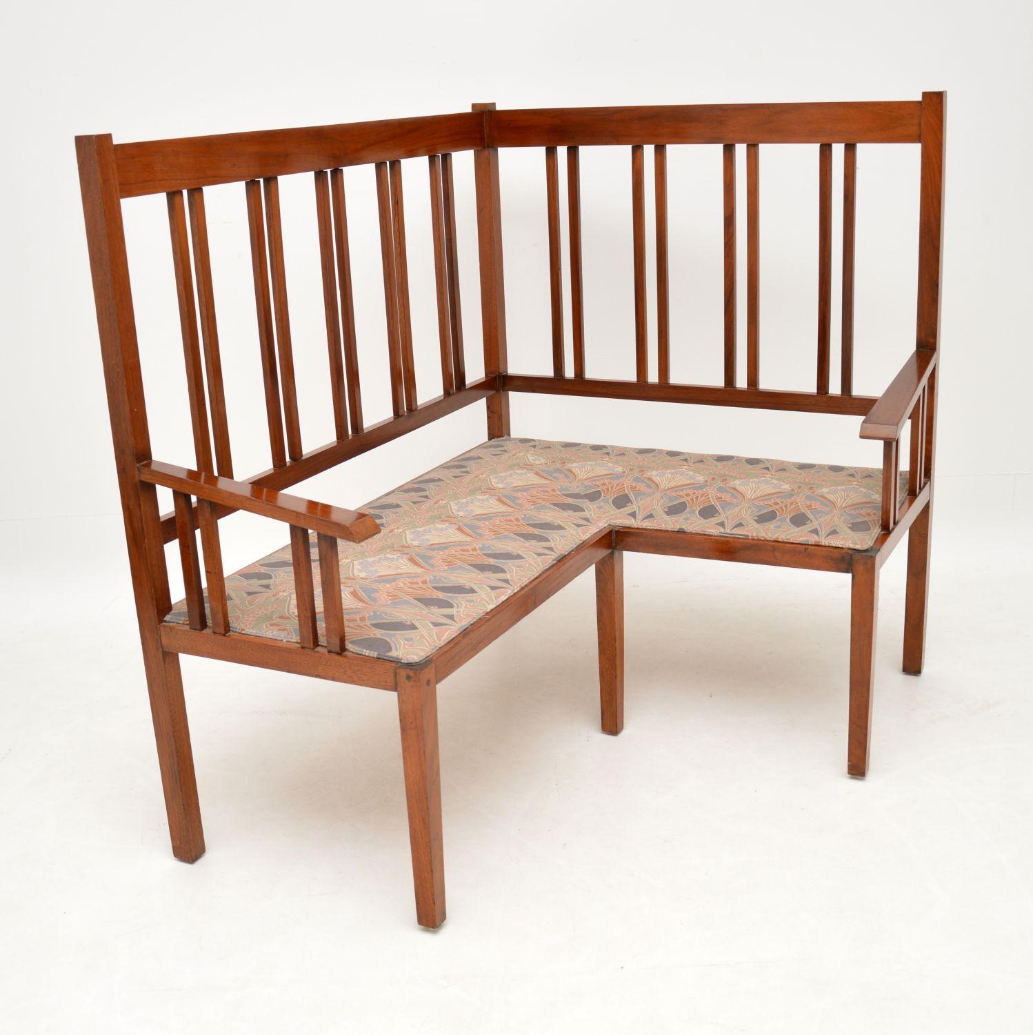 Antique Arts & Crafts corner settee in sold walnut and in good original condition.

This settee even has a William Morris design fabric on the seat, which I shouldn’t think is original, but is never-the-less perfect for this piece.

The frame is