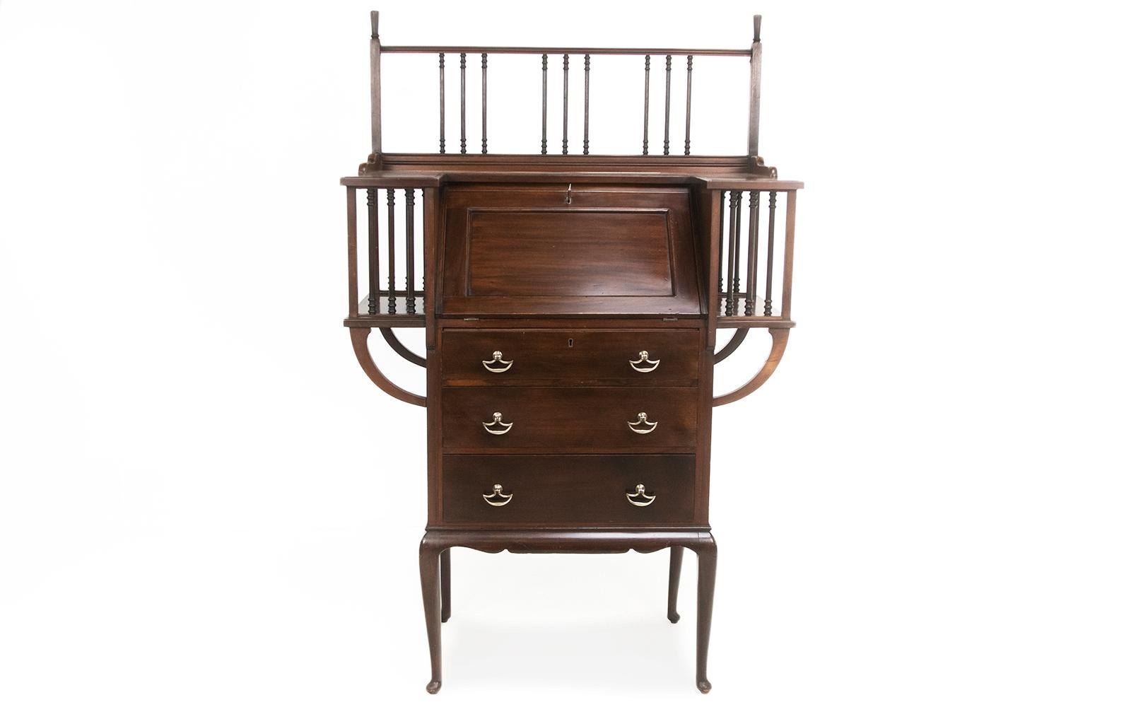 Arts & Crafts Bureau

Impactful Arts & Crafts mahogany bureau writing desk by Maple and Co, London.

'U' shaped top with a heavily spindled gallery, enclosing a fall front opening to pigeon holes, small drawers, and a skiver inset writing