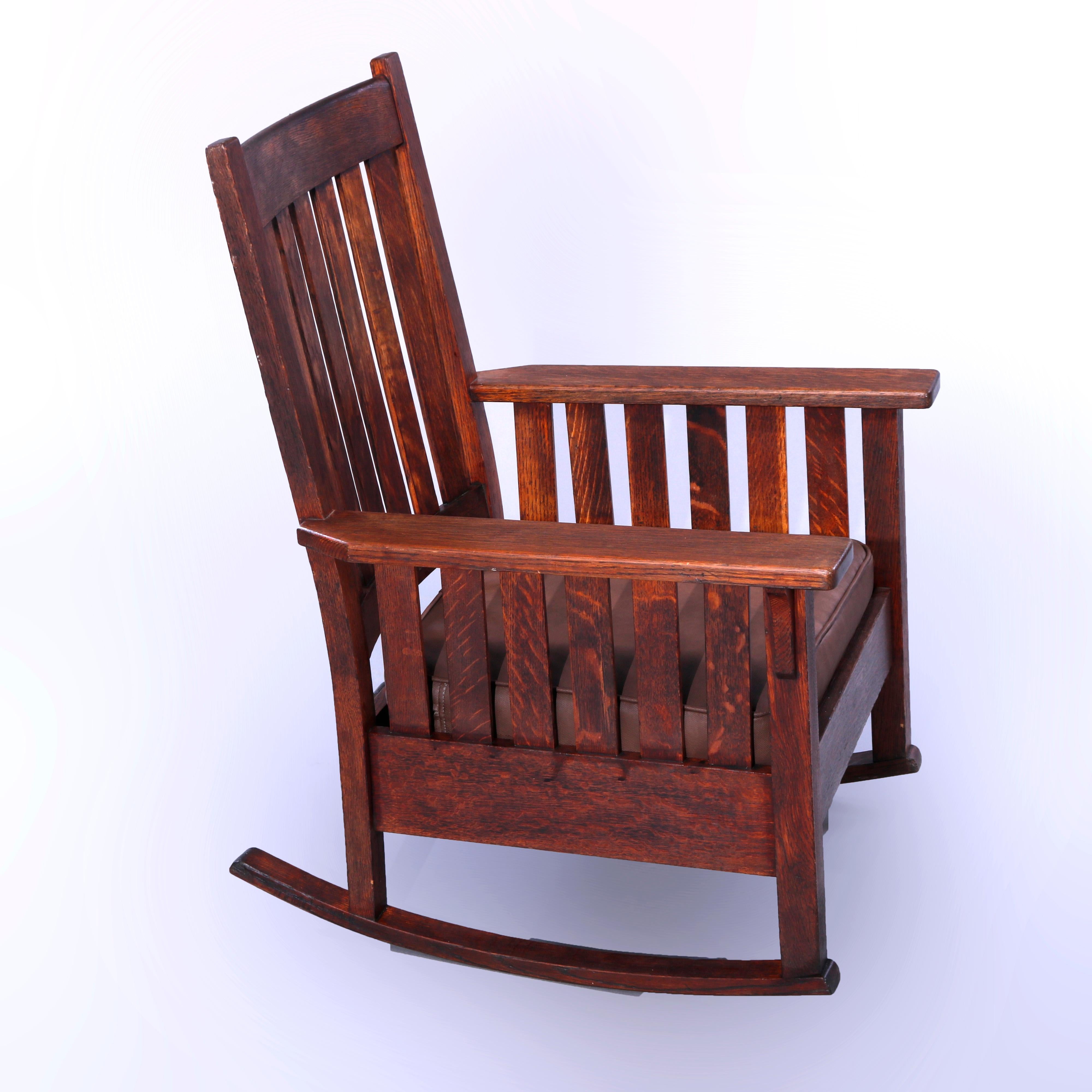An antique Arts and Crafts Mission rocking chair by Stickley Brothers offers quarter sawn oak construction with slat back and sides, circa 1910

Measures - 38.25'' H x 27.25'' W x 28'' D.