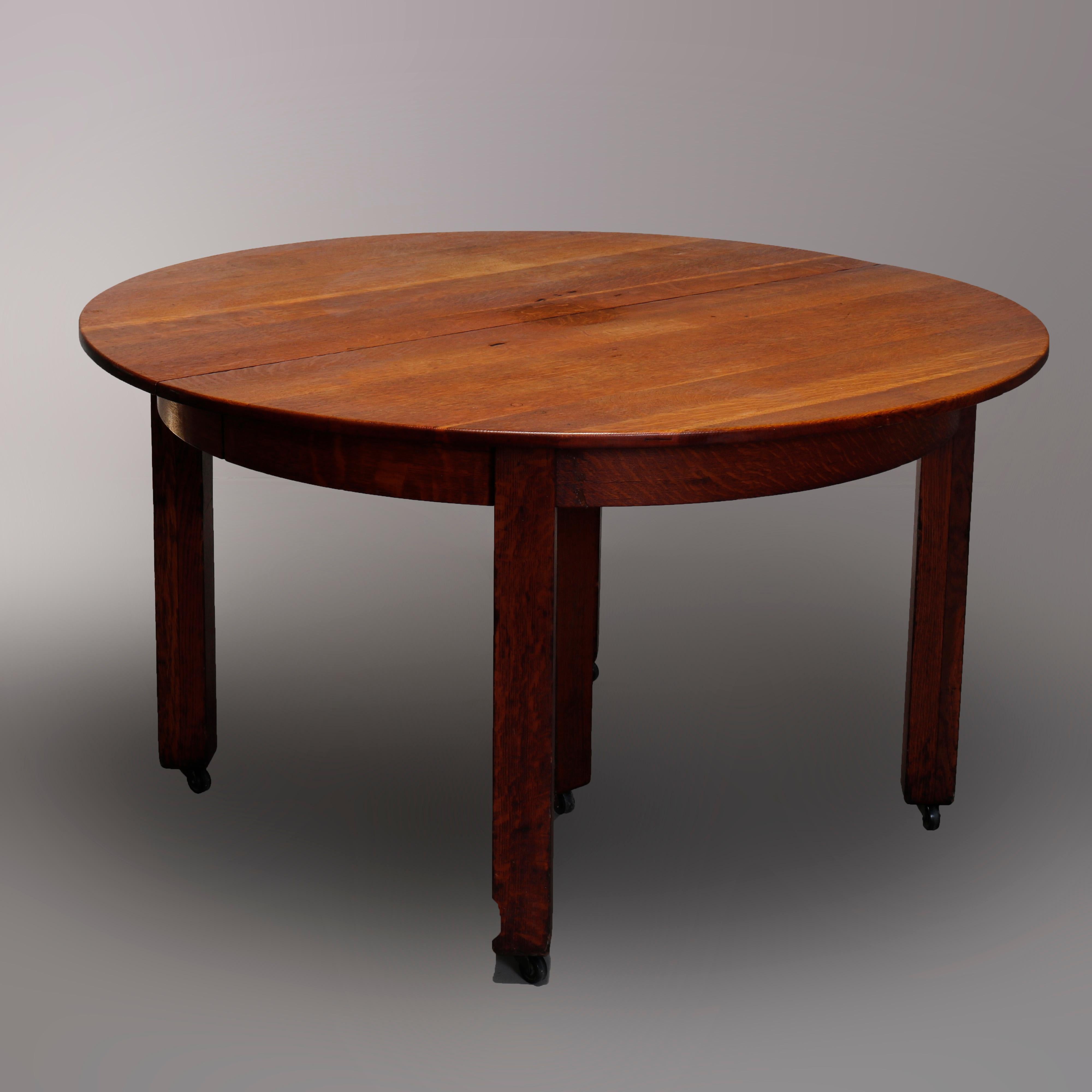 An antique Arts & Crafts Mission dining table by L & J G Stickley Handcraft Catalog #718 offers quarter sawn oak splined construction in round form with deep skirt, raised on square and straight legs, unmarked and without leaves, c1910.

Measures: