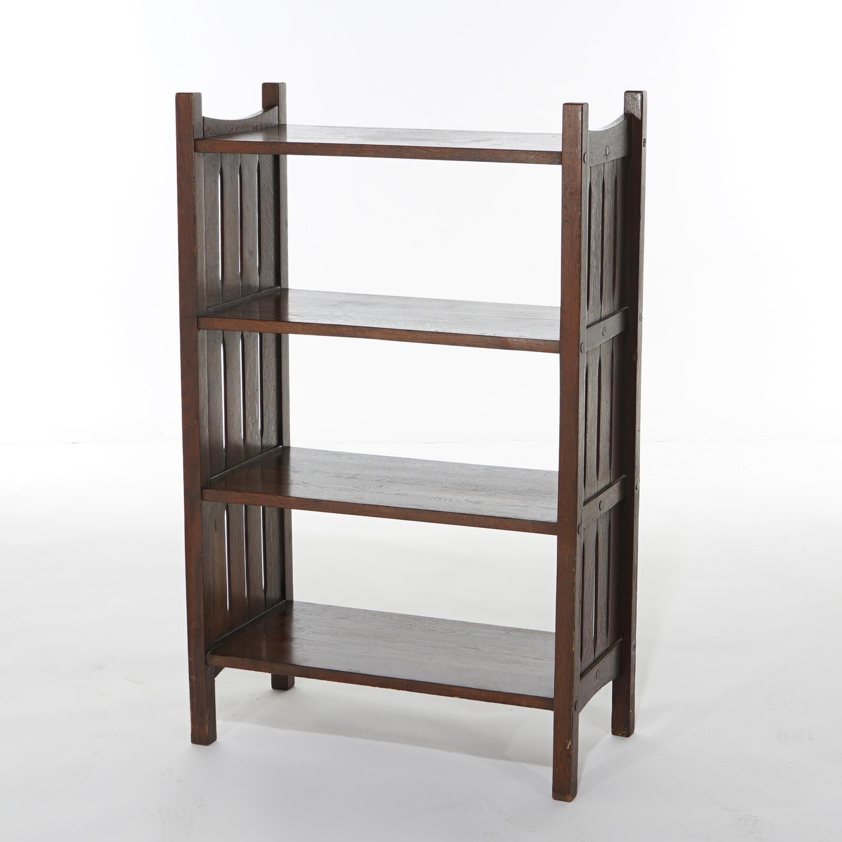 An antique Arts and Crafts bookshelf in the manner of Stickley offers oak construction with four shelves and stylized slat sides, c1910

Measures - 44.5