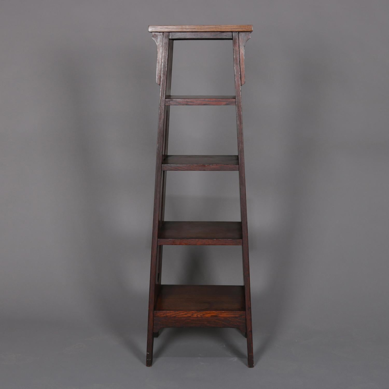 An antique Arts & Crafts stickley school mission oak school book stand features tapered form with graduated shelving and cut out sides, circa 1910.

Measures: 44