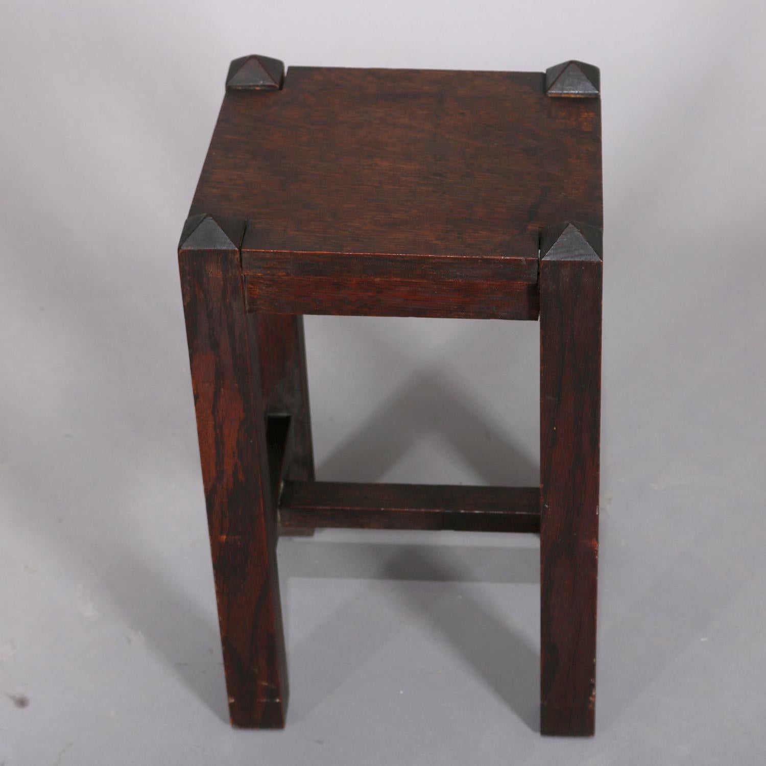 Antique Arts & Crafts Stickley School mission oak plant stand features traditional form-follows-function design with upper table raised on pyramidal square legs and joined by H-stretcher, circa 1910.

Measures: 18.5