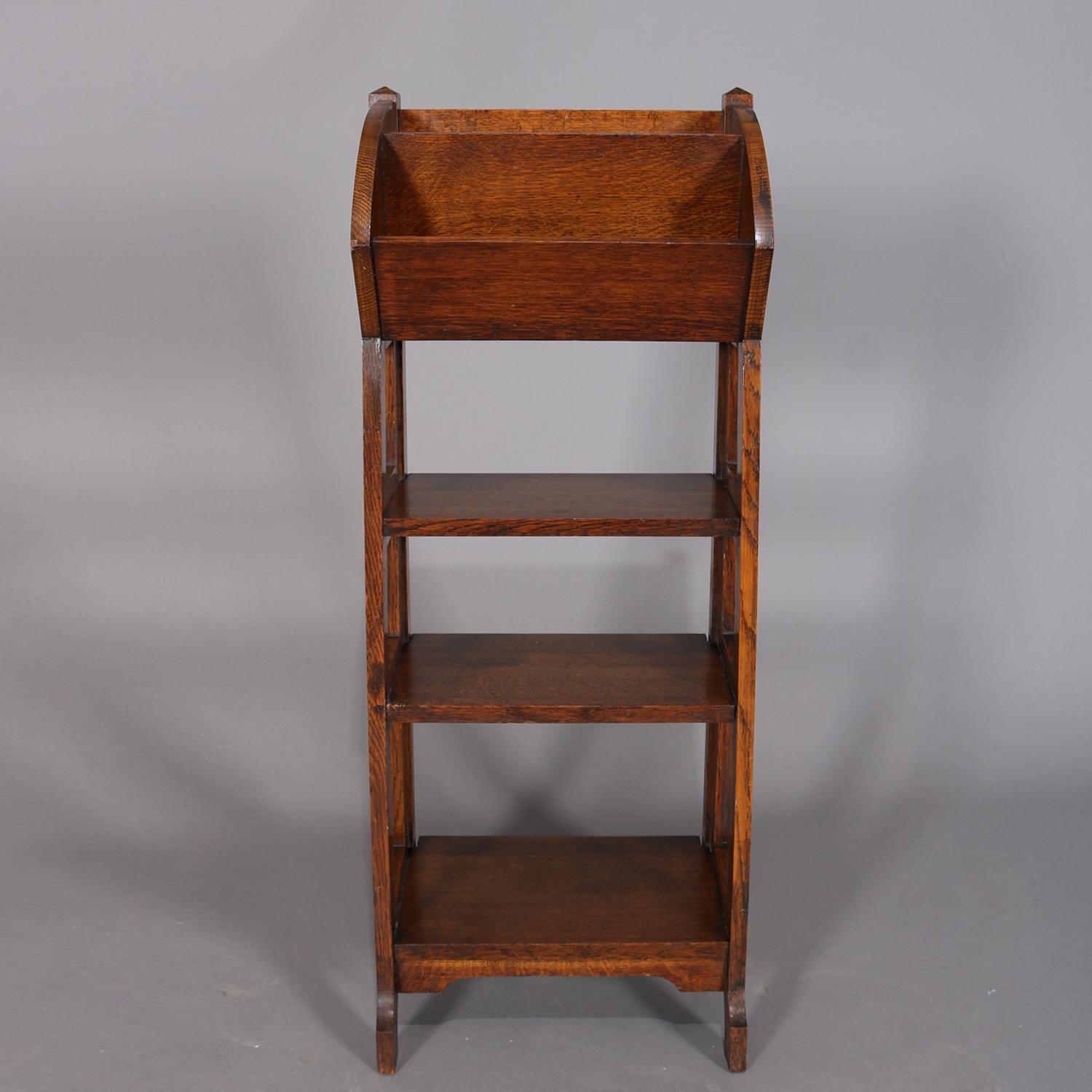 Antique Arts & Crafts Stickley School oak magazine rack features upper divided tray above three graduated lower shelves with open sides, circa 1910

Measures: 40