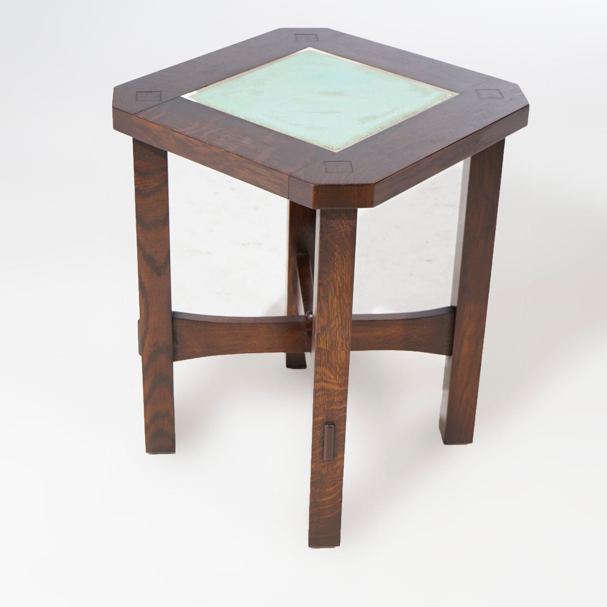 An Arts and Crafts Mission side table by Stickley offers quarter sawn oak mortise and tenon construction with clip corner top having tile insert over base with x-form stretcher, 20th century

Measures- 22.25''H x 17.25''W x 17.25''D.