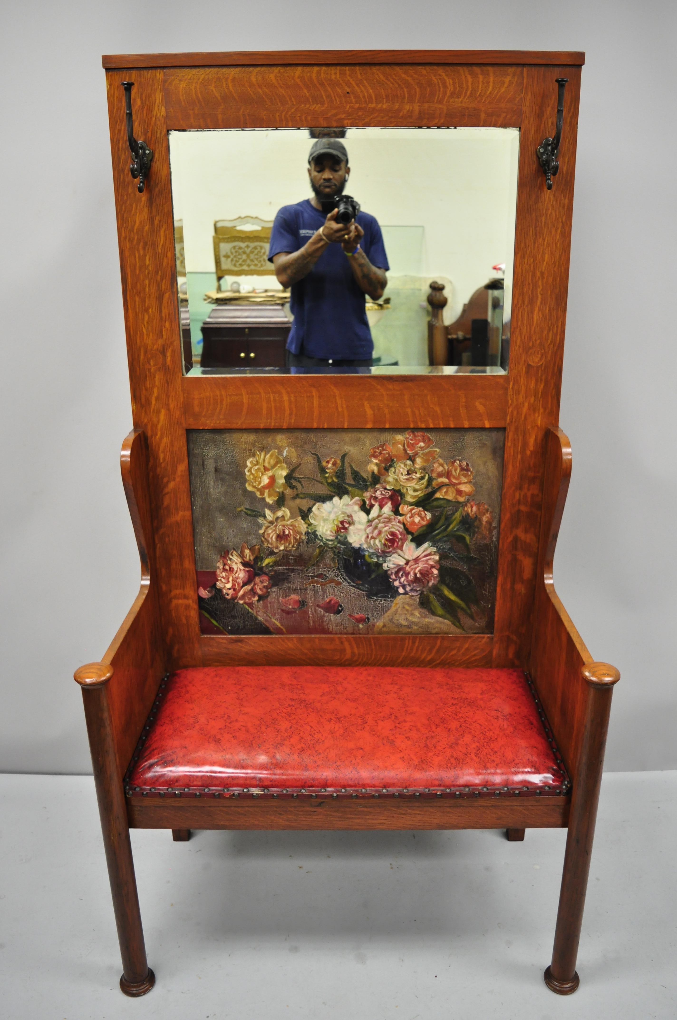 Antique Arts & Crafts tiger oak Mission hall coat tree with mirror back and bench seat. Item features large impressive size, mirror back, hand painted floral scene, 2 coat hooks, removable red vinyl seat, solid wood construction, beautiful wood