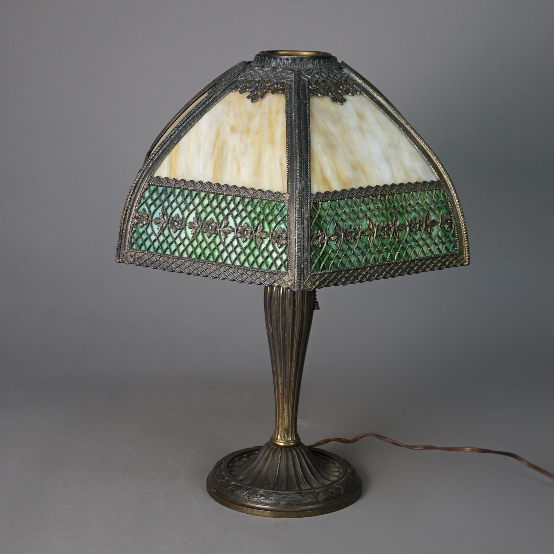 AN antique Arts and Crafts table lamp propose un abat-jour en forme de dôme avec des panneaux en verre de scorie courbé bicolore sur une base à douille unique en fonte, base estampillée AAG CO, circa 1910

Mesures - 20 