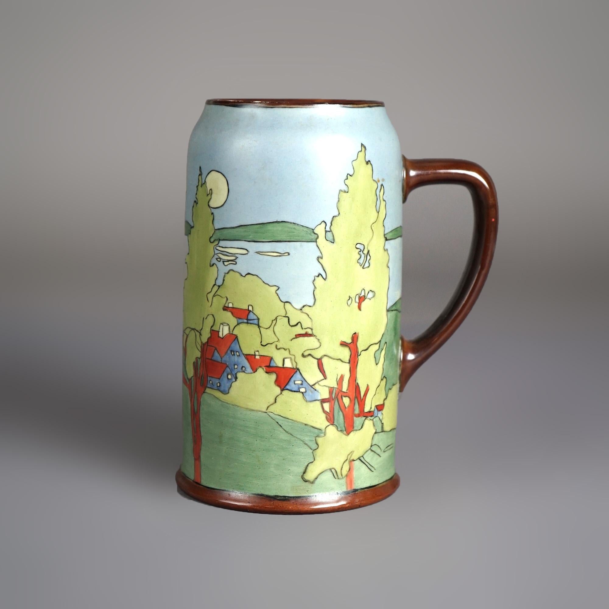 An Arts and Crafts tankard in the manner of Wesley Dow offers porcelain construction with lakeside village scene, c1900

Measures - 7.25
