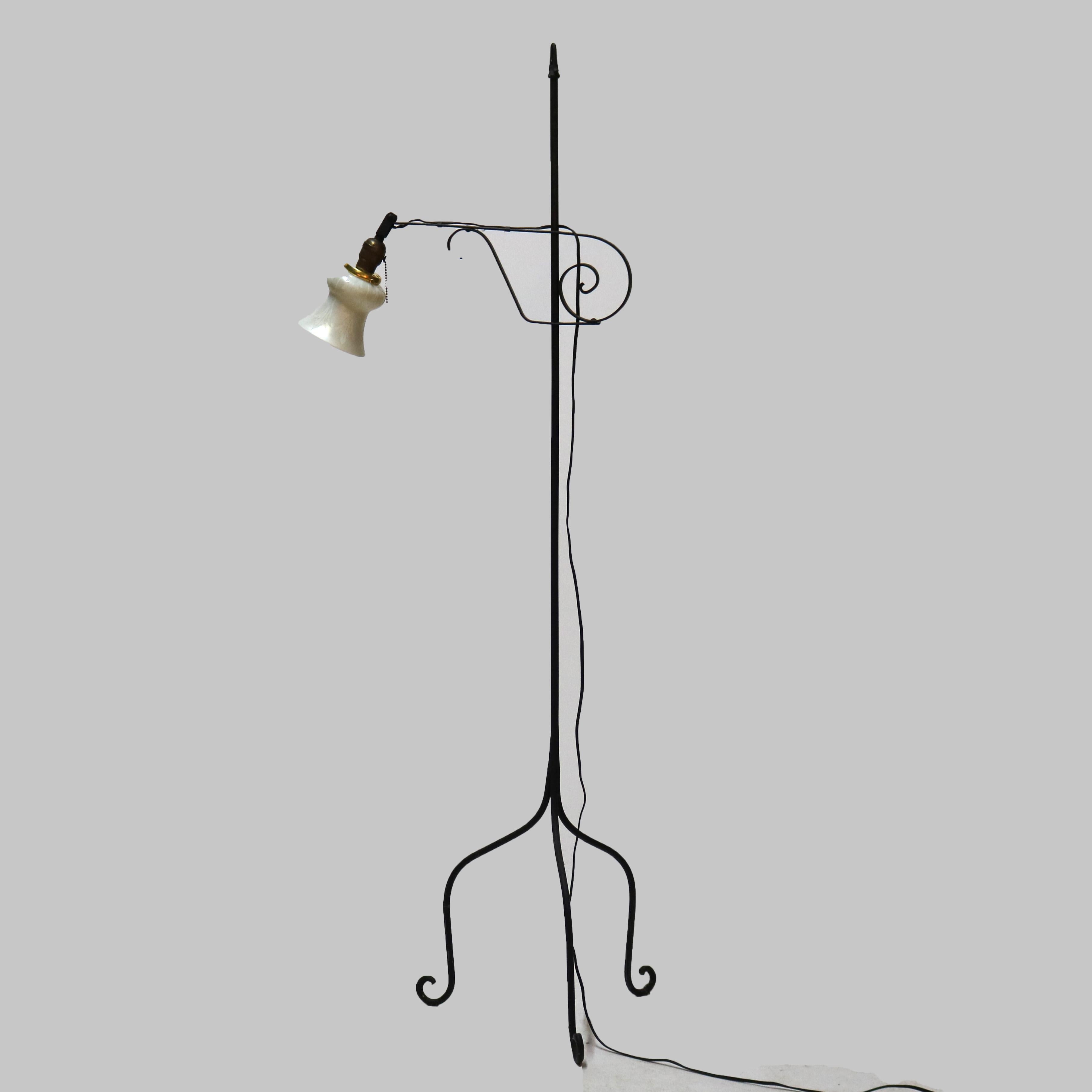 Un antique lampadaire en forme de pont Arts & Crafts offre une base en fer forgé avec un bras réglable en forme de volute se terminant par une lumière avec un abat-jour en verre d'art Steuben gravé et reposant sur trois pieds en forme de volute,