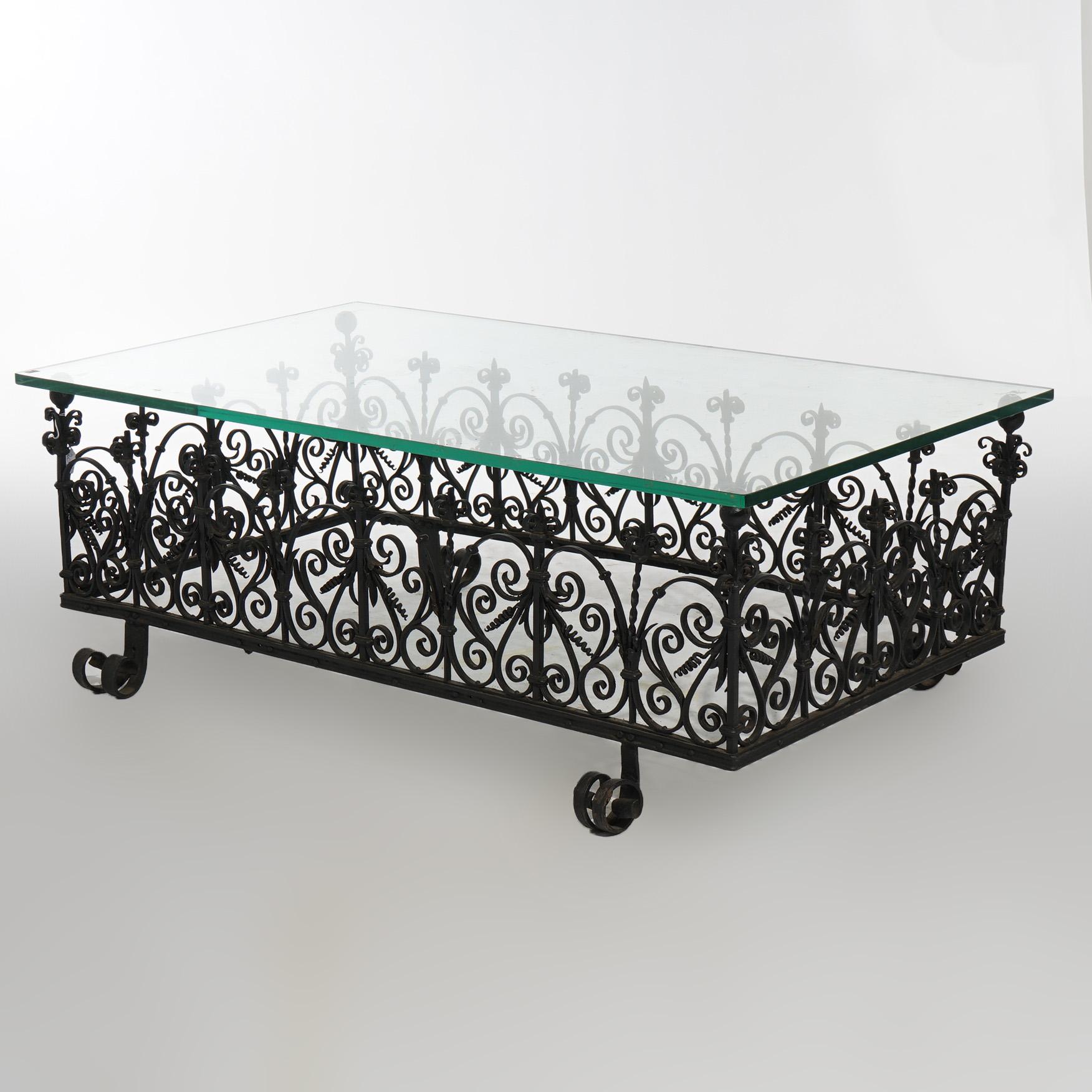 An antique Art and Crafts low table in the manner of Yellin offers glass top over scroll and stylized foliate form wrought iron base, c1920

Measures - 19.75