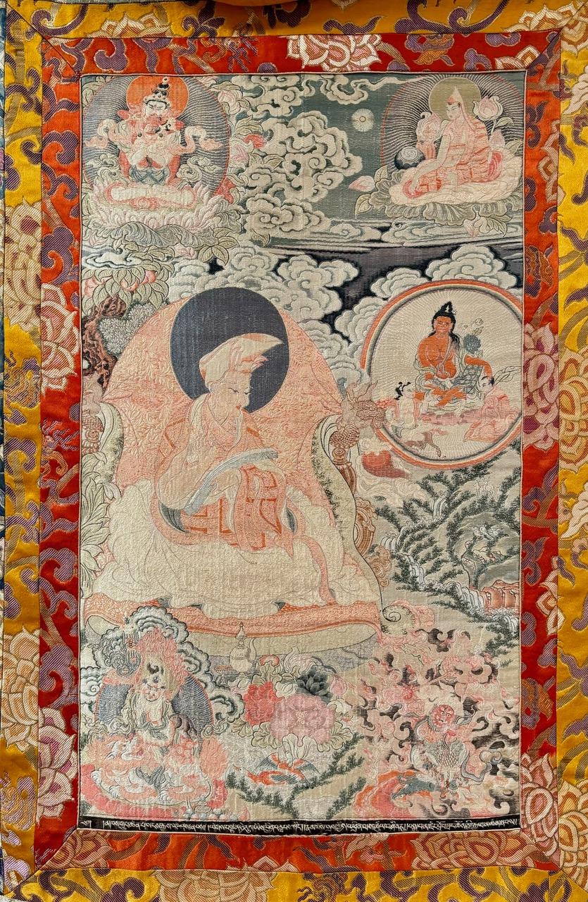 This rare antique 1920s embroidered silk Tibetan Thangka depicts images seldom seen of the greatly radicalized ones radiating divine love. The bottom left depicts Dzambhala, the Buddha of wealth and generosity. On the bottom right is Dharmpala, the