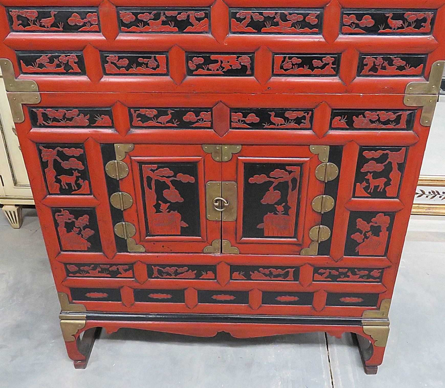 Antique Asian cabinet with four drawers and four doors.
