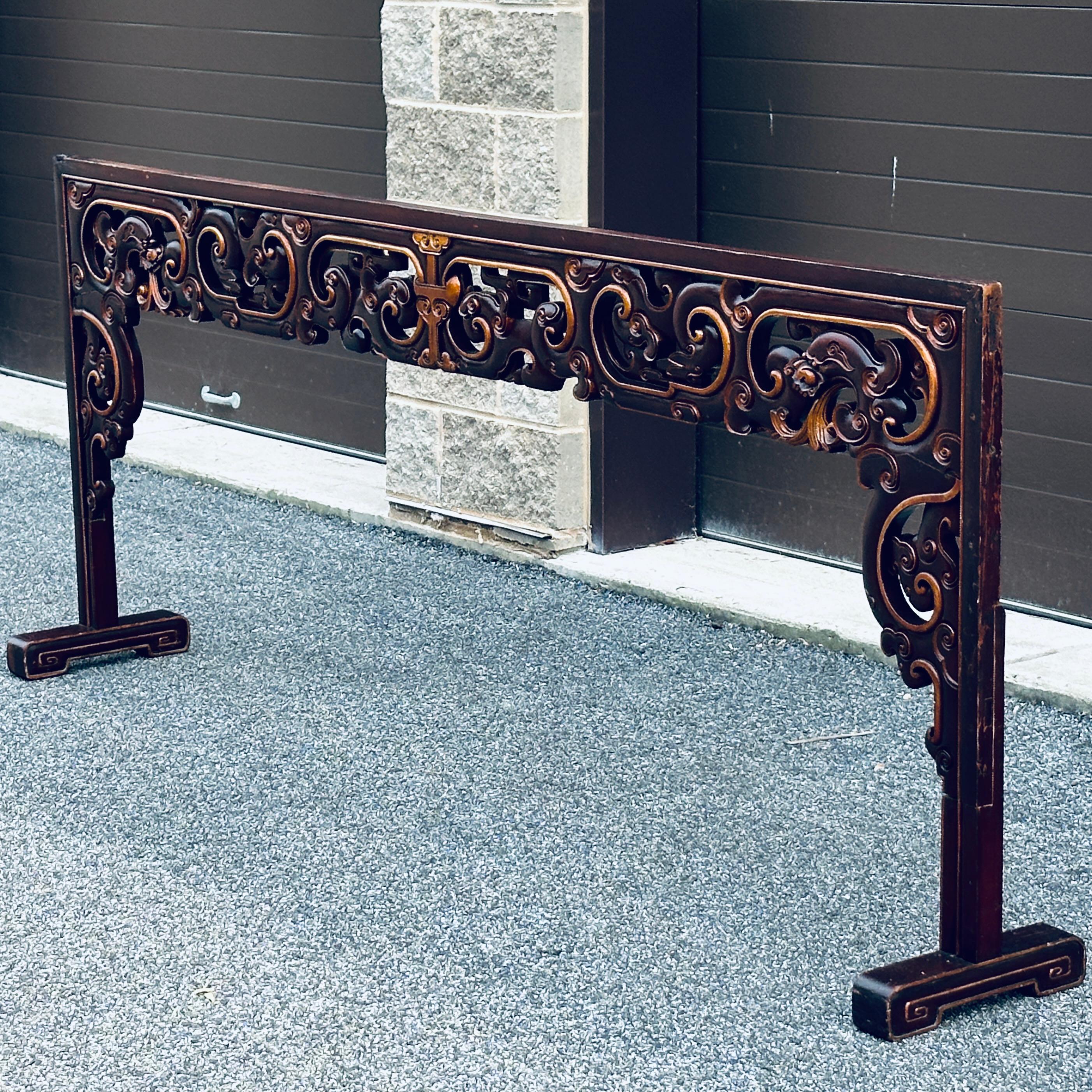 Antique Asian carved and painted headboard dragons heads design and openwork. Carved solid wood with deep red painted finish with gilt highlights. Measures 88” wide between the legs.