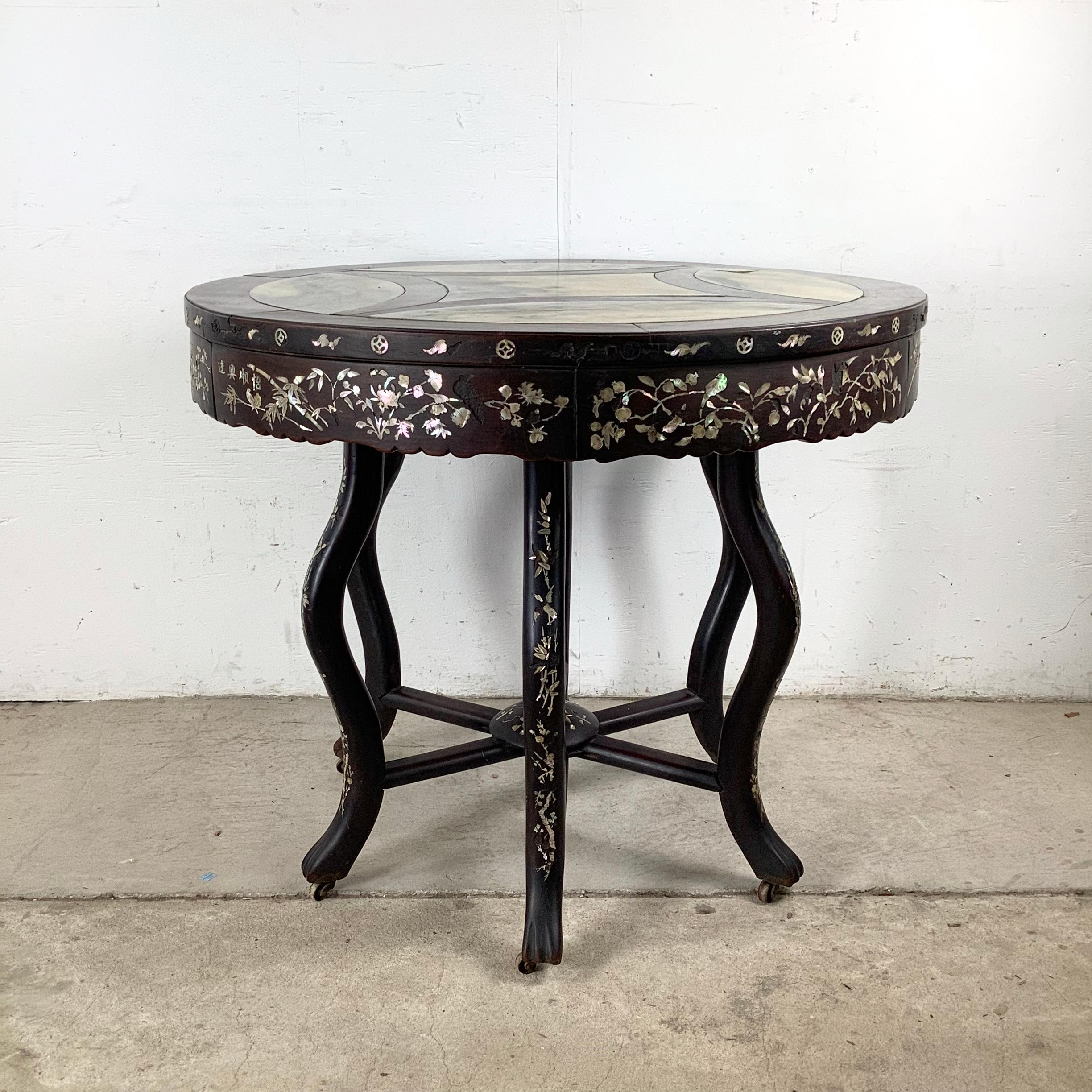 This decorative round center table combines timeless beauty with functional versatility. The polished grey marble inset top is framed by dark hardwood, offering an elegant contrast of texture and color. A refined centerpiece for any room, the design