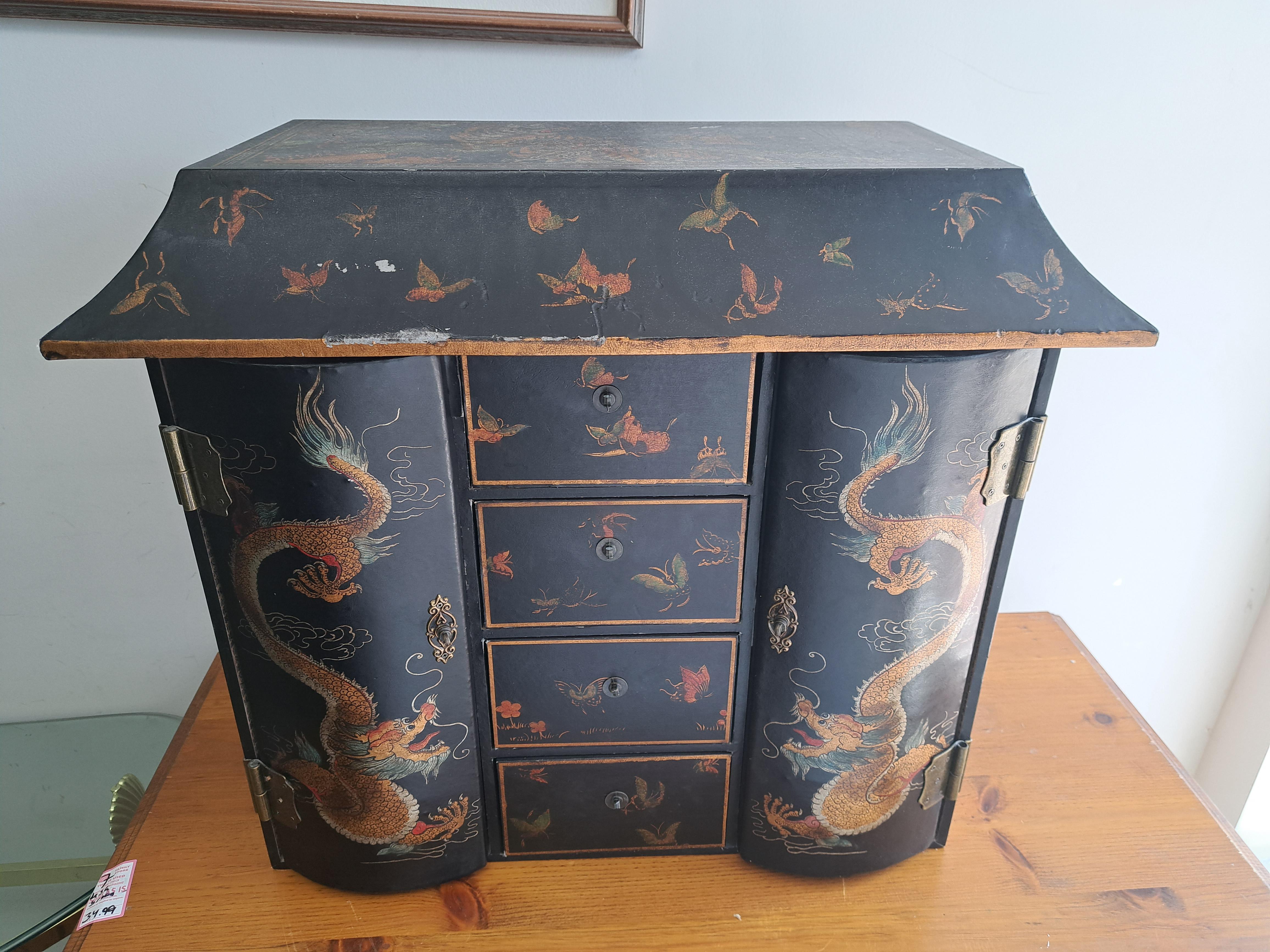 Antique Asian tea/apothecary  cabinet.. Pagoda shaped cabinet has two doors and four drawers. Wood with detailed brass fittings. Painted Chinoiserie black with gold and colored details such as dragons and flowers.