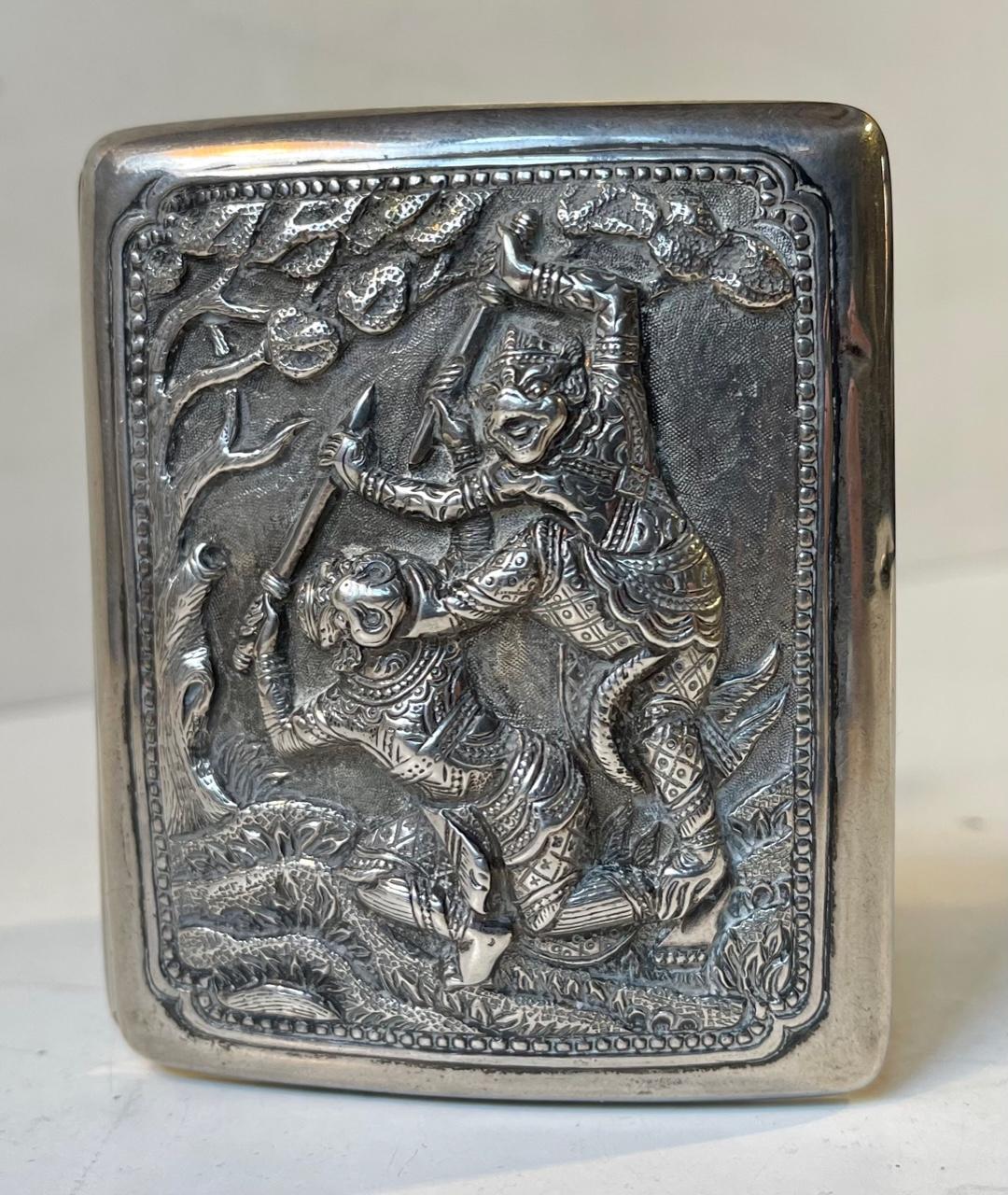 A fine entirely handcrafted antique cigarette case with a gilded interior. Its front depicts a battle scene where the warriors, presumably Chinese Gods, wears mythological masks. We believe one of them is of Kailu or Kaishan. The details to the