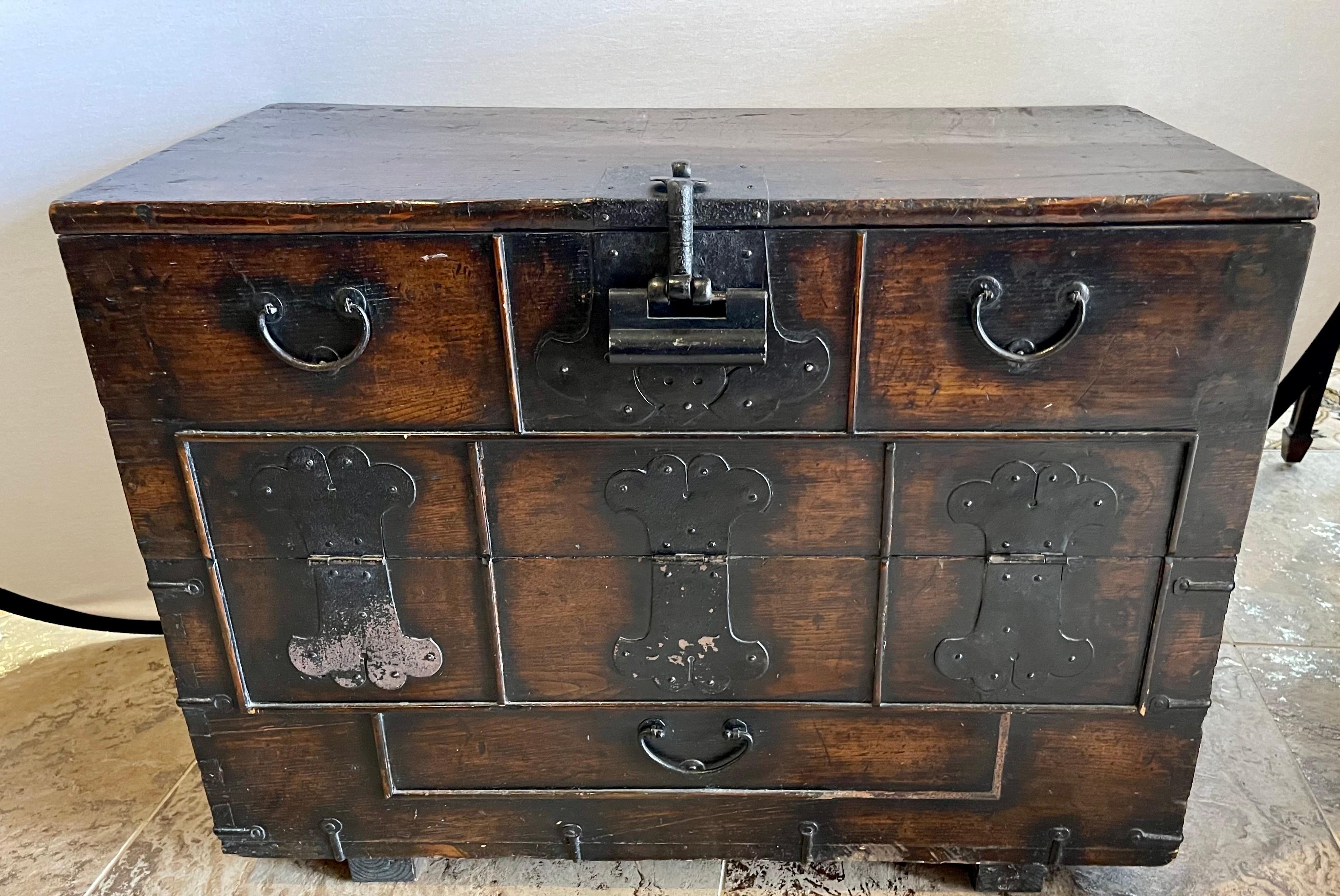 Antique Korean Bandaji Blanket Chest is made from elm and pine and is embellished with patina iron fittings and hinges. It has a drop down door that opens to a large interior storage area for clothes or valuables.