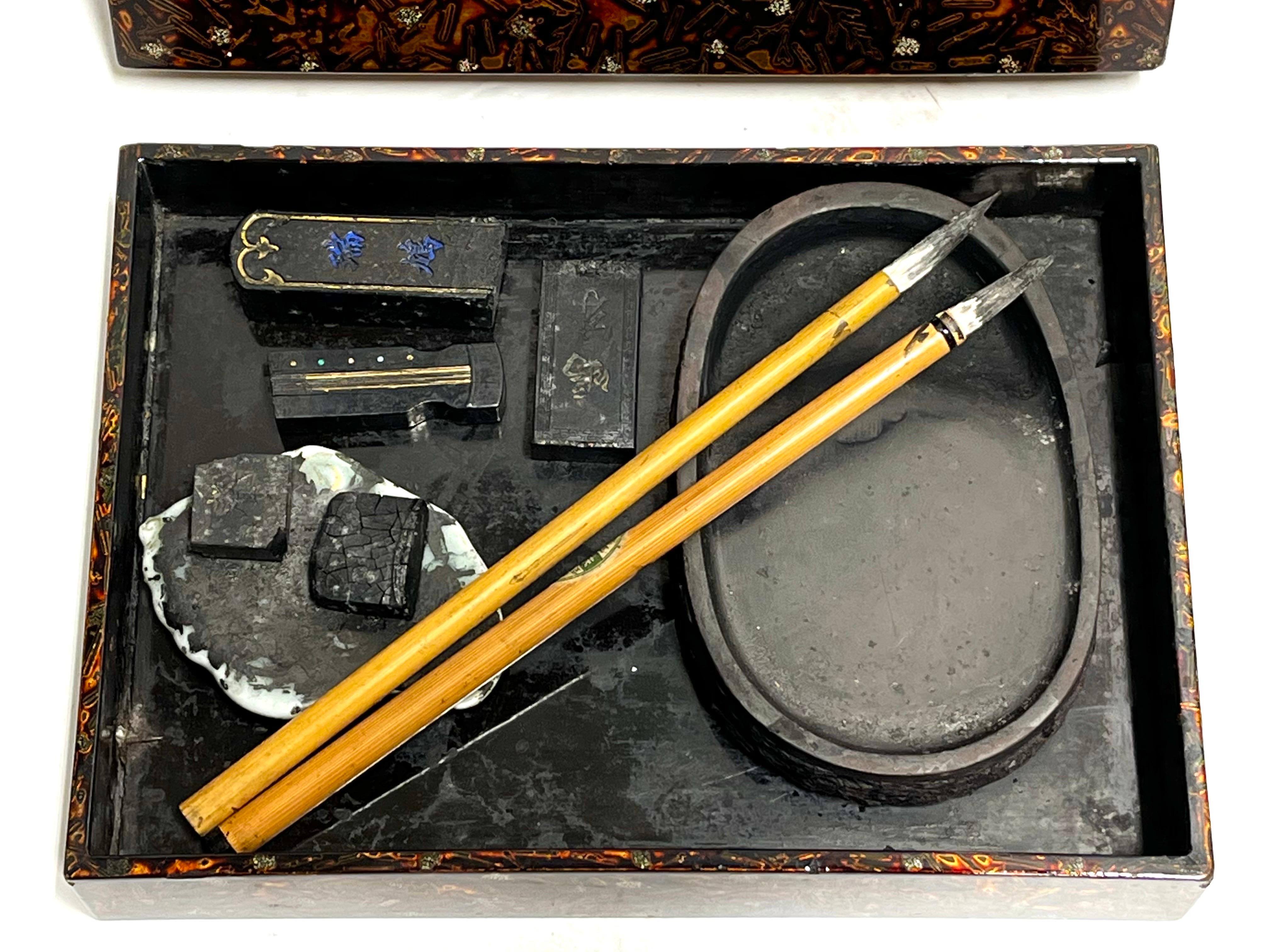 An antique Asian, lacquered and signed wood writing or calligraphy box with carved and signed ink stones and brushes. This set has been used. For a bit about the history of lacquer I offer an excerpt from an article on the visual arts website, 