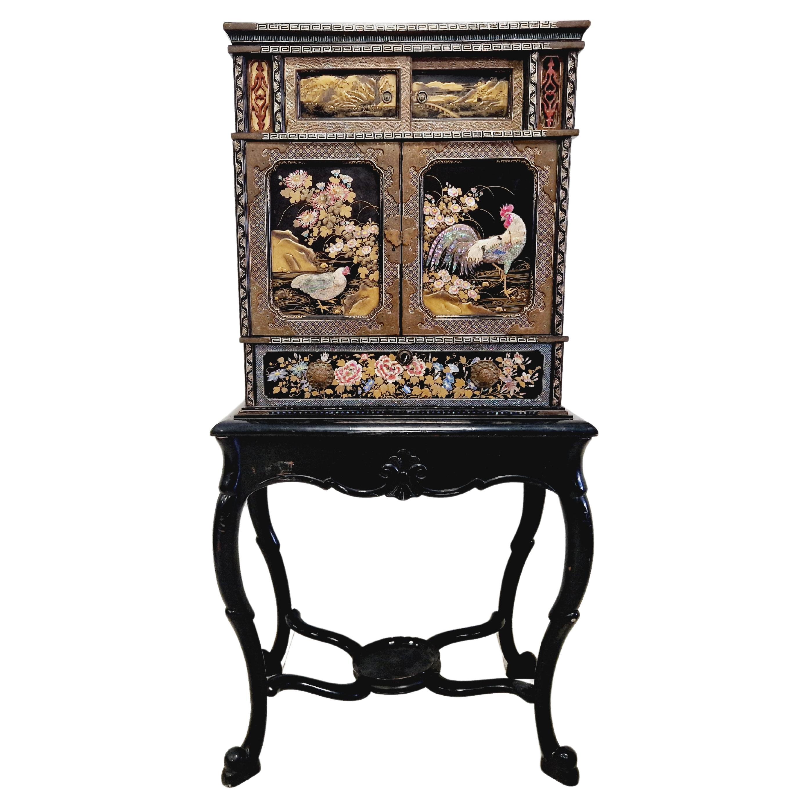 Este antiguo armario japonés lacado es un hermoso mueble perfecto para cualquier coleccionista de muebles antiguos. El mueble es de madera y se ha fabricado a mano con un acabado en relieve. El diseño presenta un tema japonés con pájaros y unas