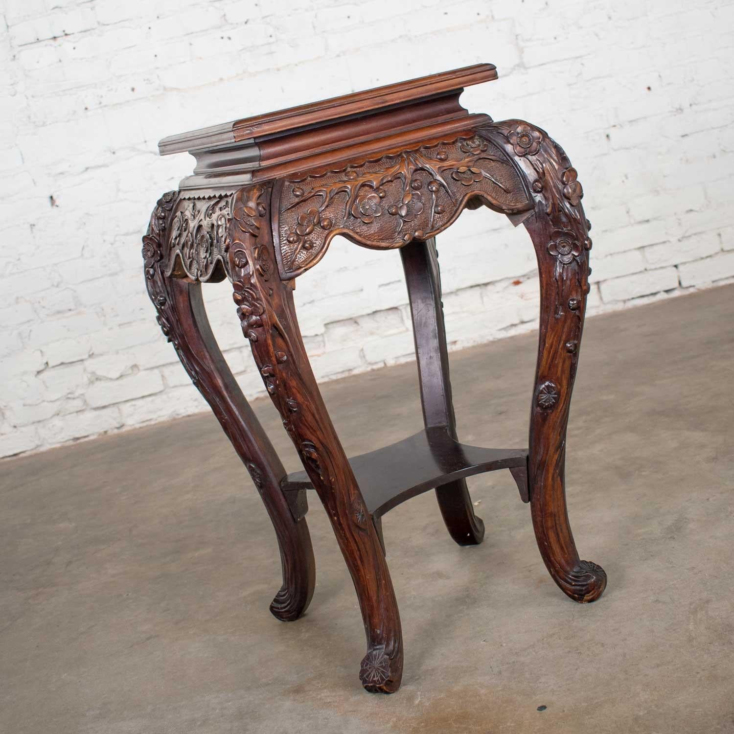 Stunning antique Asian pedestal table with hand carved cherry blossoms rosewood color and comprised of multiple Asian hardwoods. It is in beautiful vintage condition, it is sturdy and intact and has been completely re glued and touched up. Age