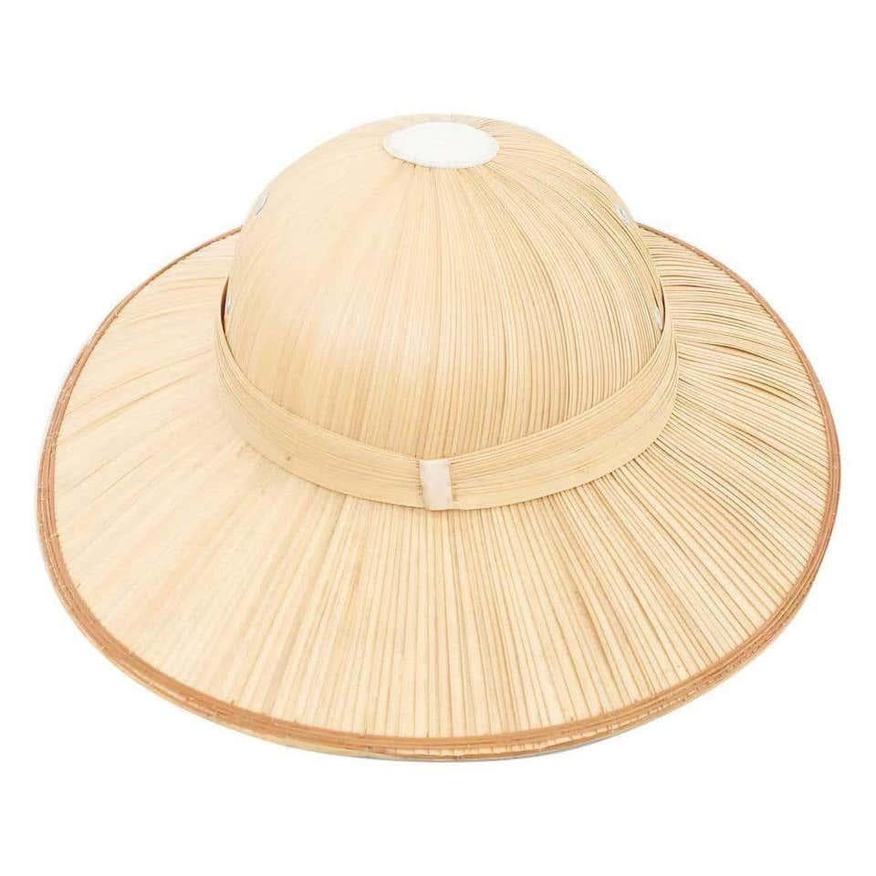 Asian Hat, circa 1950. By unknown manufacturer, from Asia.  In original condition, with some visible signs of previous use and age, preserving a beautiful patina.  Materials: Rattan  Dimensions: D 38 cm x W 32 cm x H 14 cm.