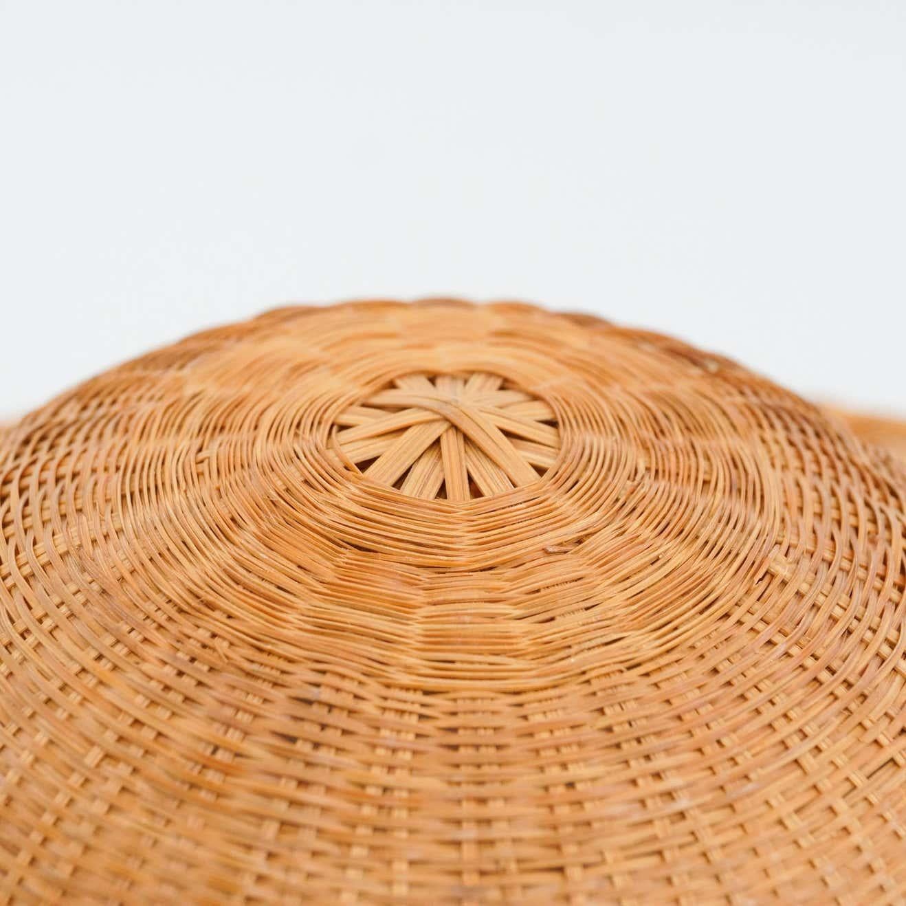 Asian hat, circa 1950.
By unknown manufacturer, from Asia.

In original condition, with some visible signs of previous use and age, preserving a beautiful patina.

Materials:
Rattan

Dimensions:
ø 37.5 cm x H 11 cm.