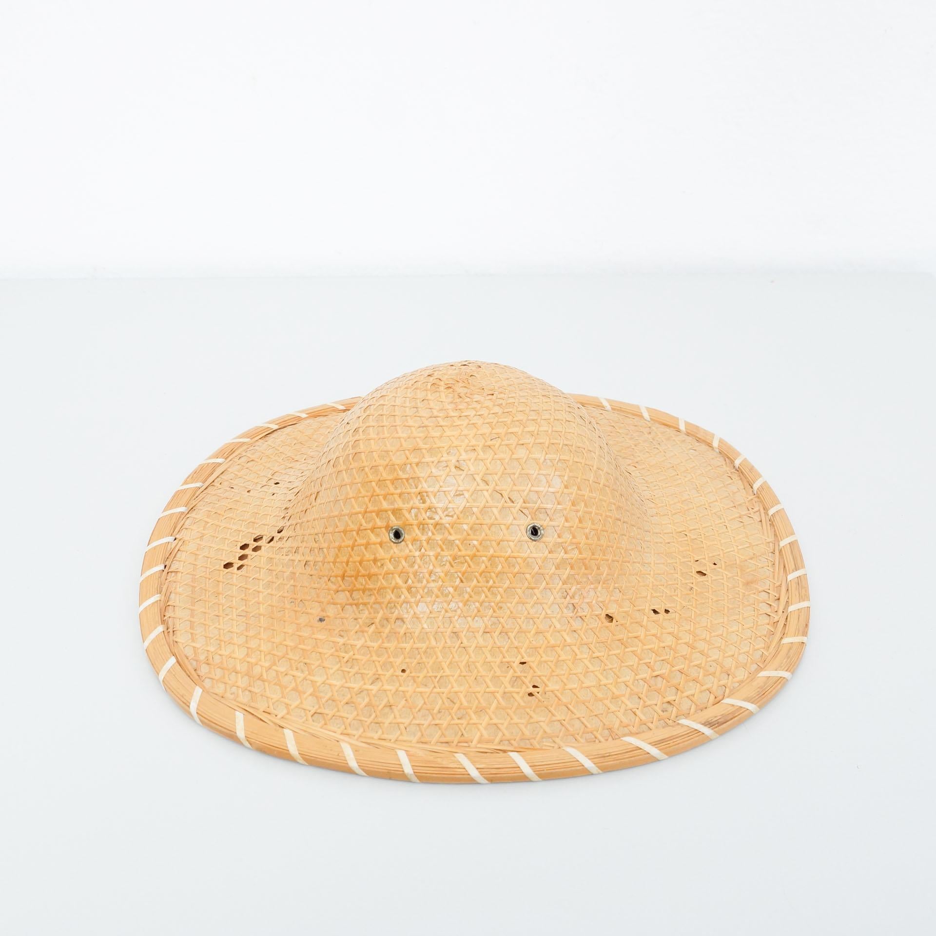Asian hat, circa 1950.
By unknown manufacturer, from Asia.

In original condition, with some visible signs of previous use and age, preserving a beautiful patina.

Materials:
Rattan


