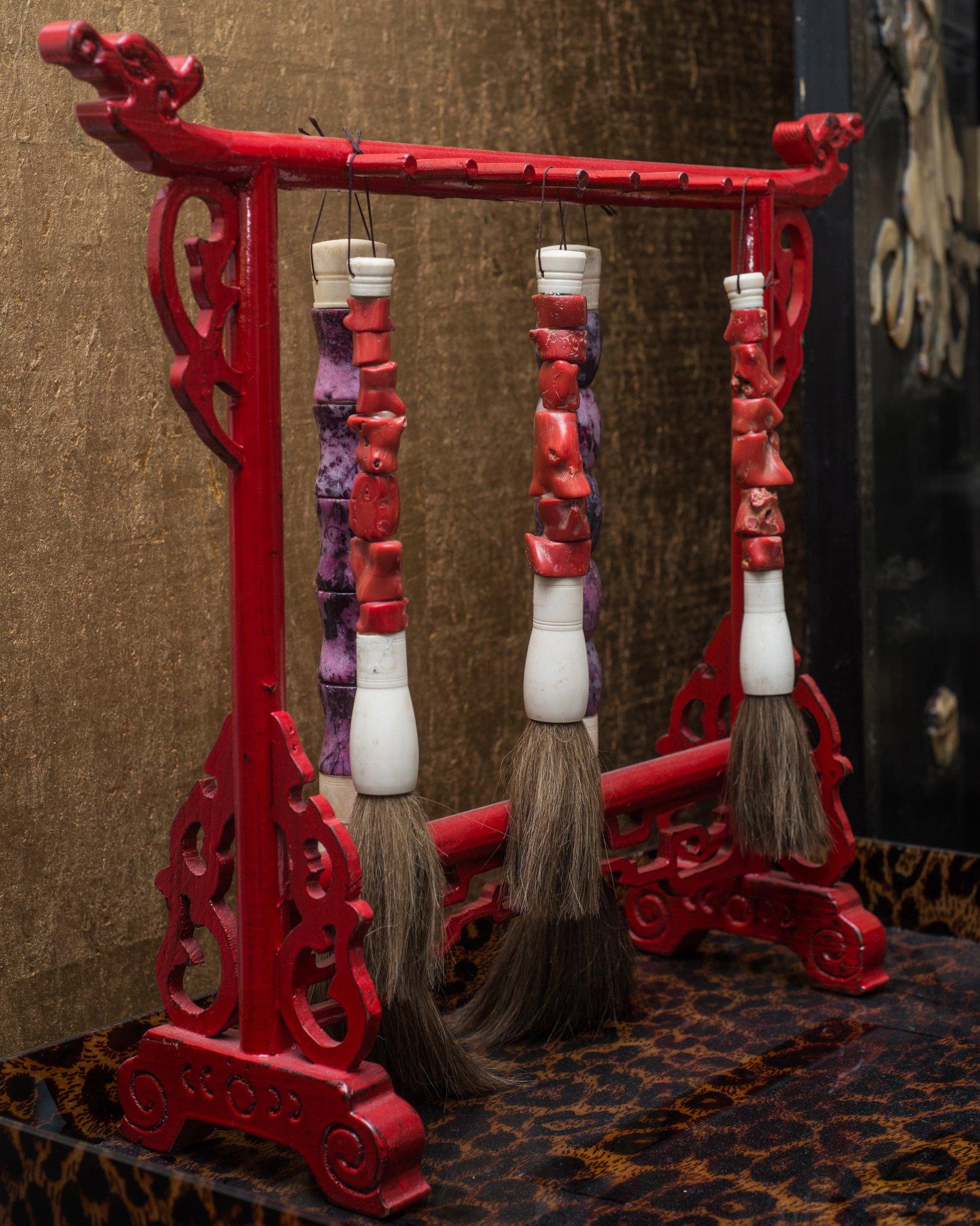 This beautiful unique red lacquered stand is used to present calligraphy horsehair brushes that are made of antique pieces of bone, coral and purple semi-precious stone. Typically used with an open ink well to write characters, calligraphy is as