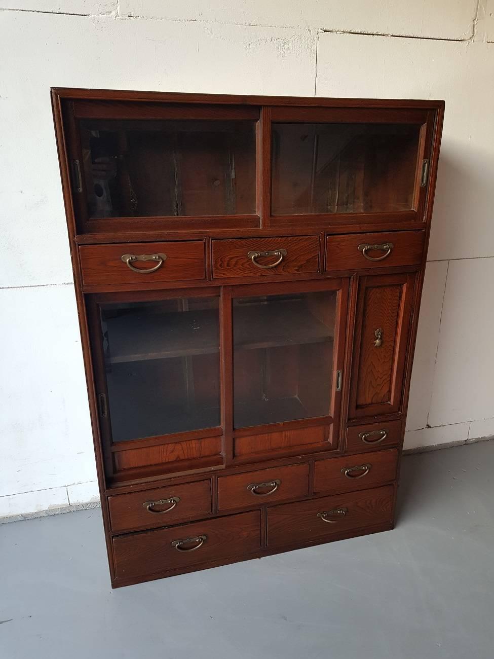 Antique Asian cabinet from circa 1900 and is made of rose wood with different size drawers and sliding doors provided with facet cut-glass.

The measurements are:
Depth 35 cm/ 13.7 inch.
Width 85 cm/ 33.4 inch.
Height 120 cm/ 47.2 inch.
 