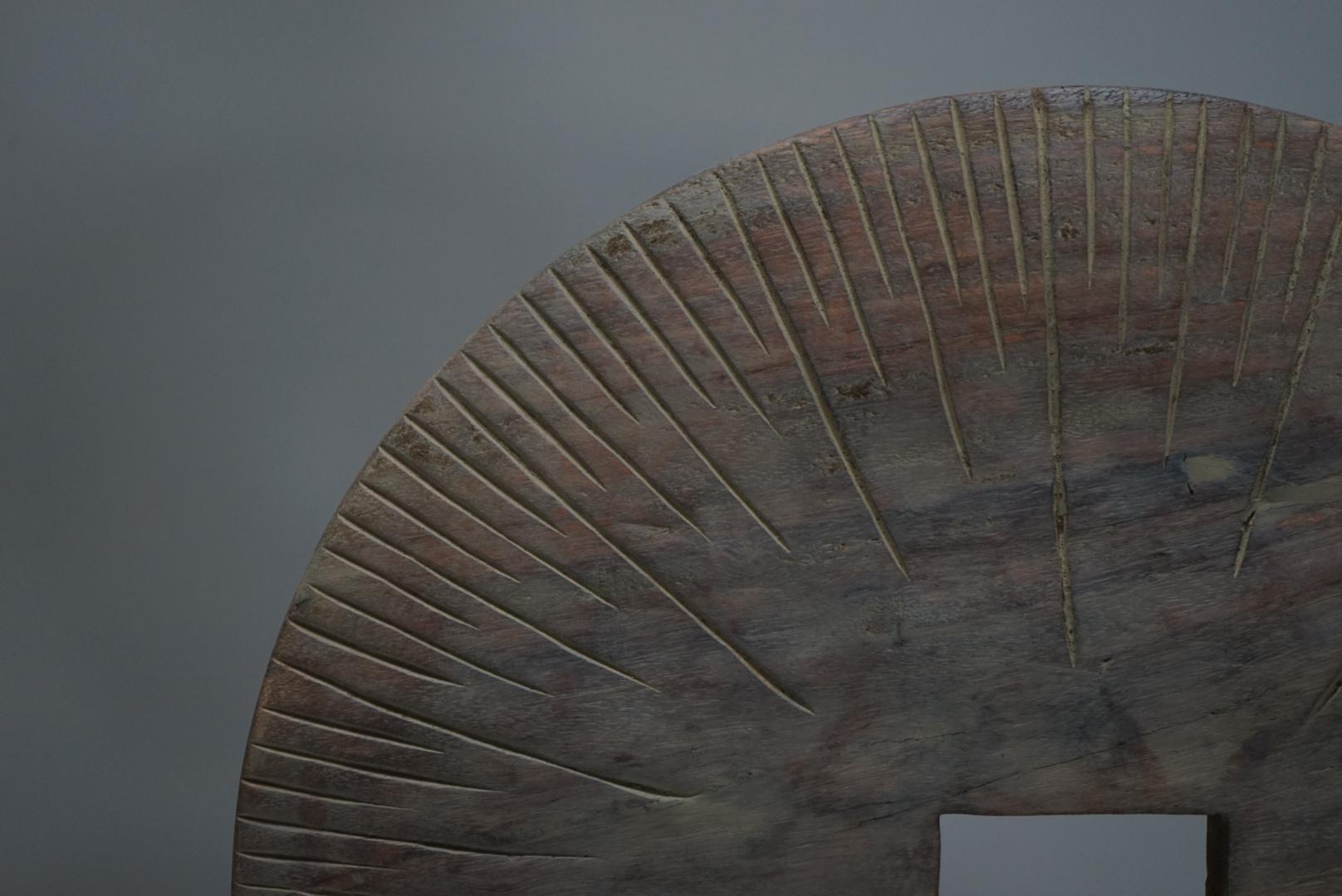 An Asian vintage sculptural object of unknown origin and date, carved from a solid disc of wood and elevated on a simple stand.
The circular form has been shaped by hand, resulting in a primitive presence that feels both raw and quietly