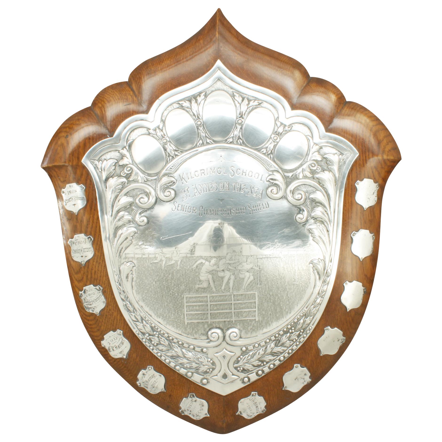 Presentation Shield Trophy, Walker and Hall.
A large freestanding, oak Athletics Shield Trophy with Sheffield plate decoration. The 'Senior Championship Shield' was presented by Kilgrimol School, St. Annes-on-the-Sea and was manufactured by the