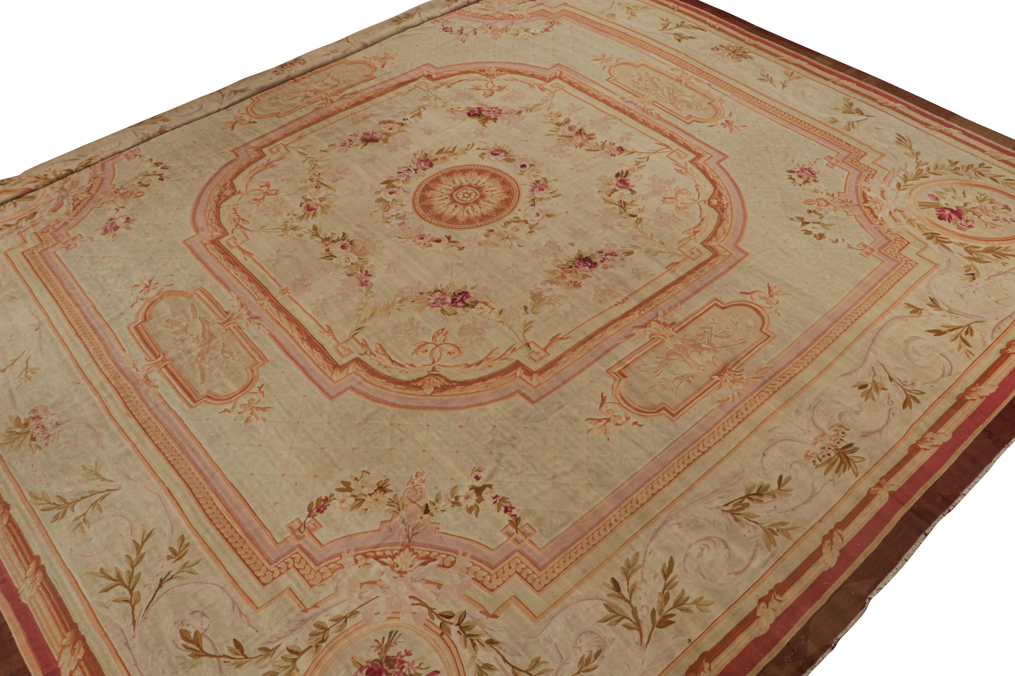 Dieser 17x17 große antike Aubusson-Teppich aus Wolle, handgewebt um 1890-1900, ist ein seltenes Meisterwerk aus der Zeit der Jahrhundertwende. Das Design zeigt reiche rote, rosafarbene und braune architektonische Bordüren um ein cremefarbenes Feld
