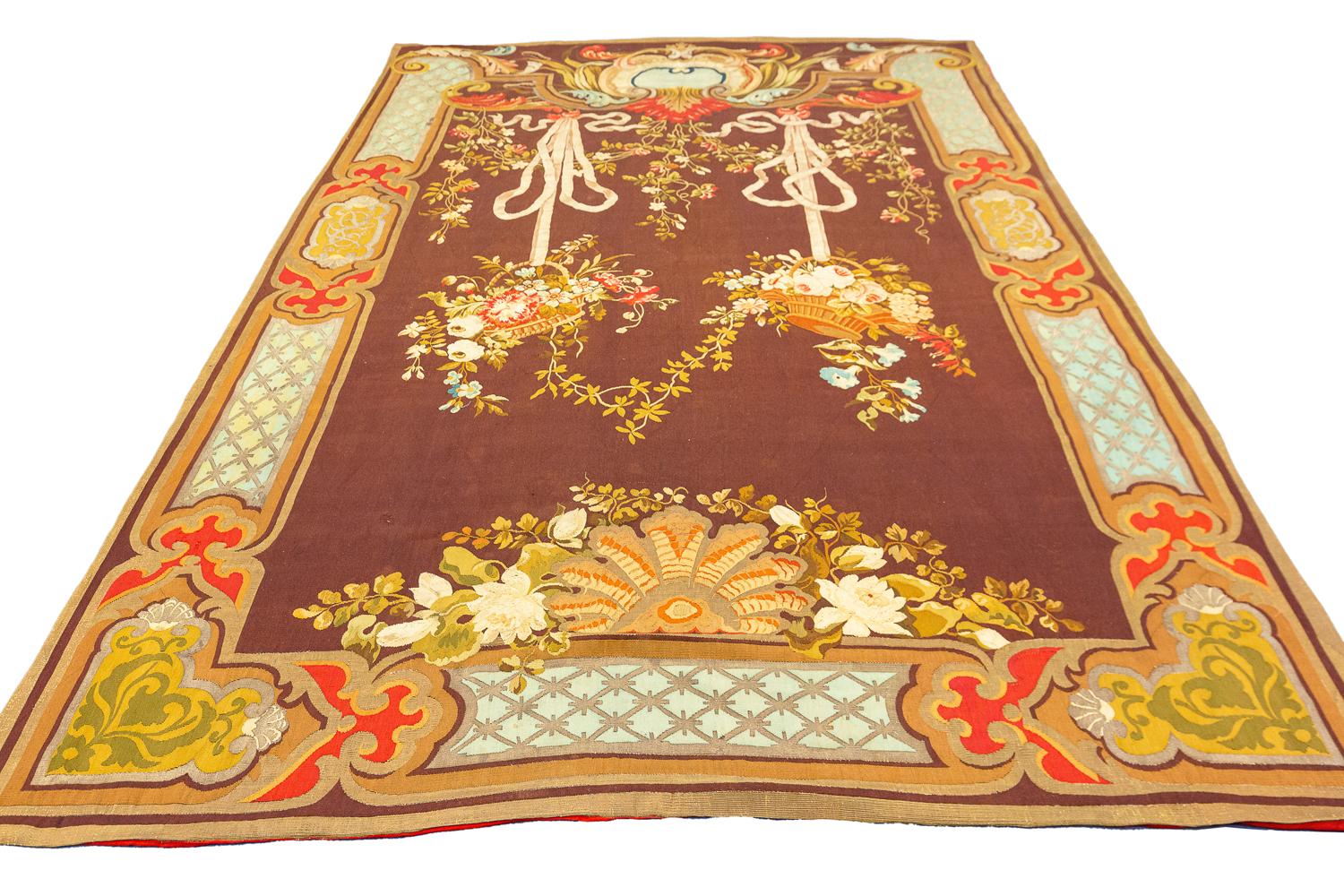 Il s'agit d'une tapisserie ancienne d'Aubusson fabriquée en Europe à la fin du 19e siècle.  mesure 302x196 CM. Cette pièce présente un motif floral avec deux bouquets à l'intérieur de paniers qui sont attachés par des nœuds papillon au cadre